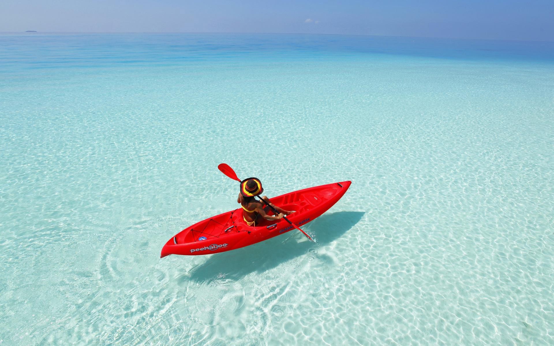 Woman kayaking in clear turquoise ocean water HD Wallpaper