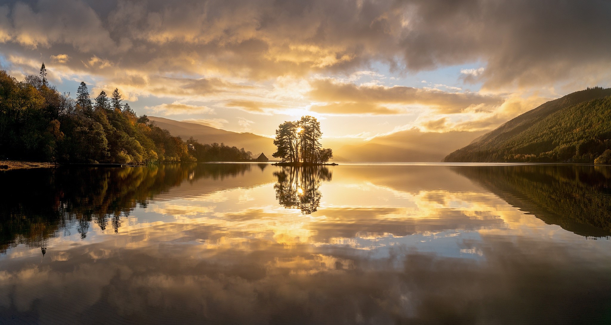 Island with trees on lake at sunset with reflection HD Wallpaper