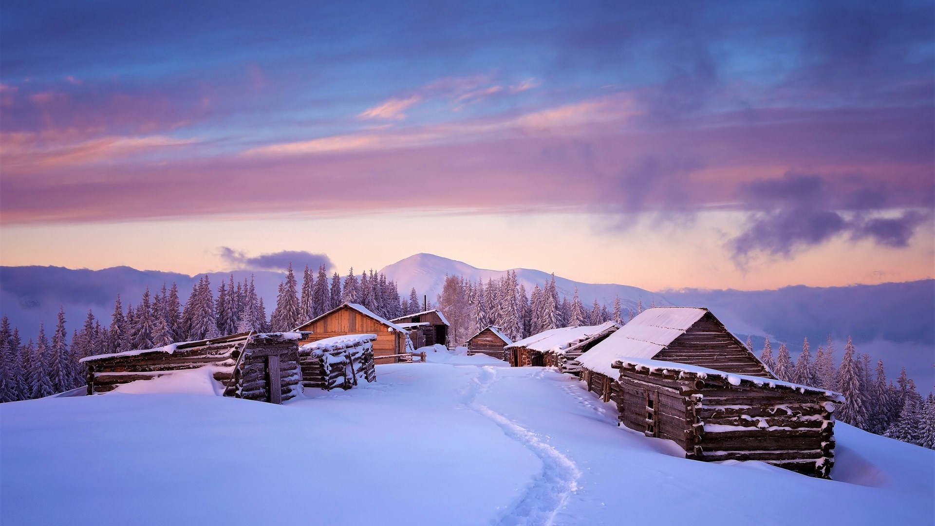 Snowy mountain village at sunrise with wooden cabins HD Wallpaper