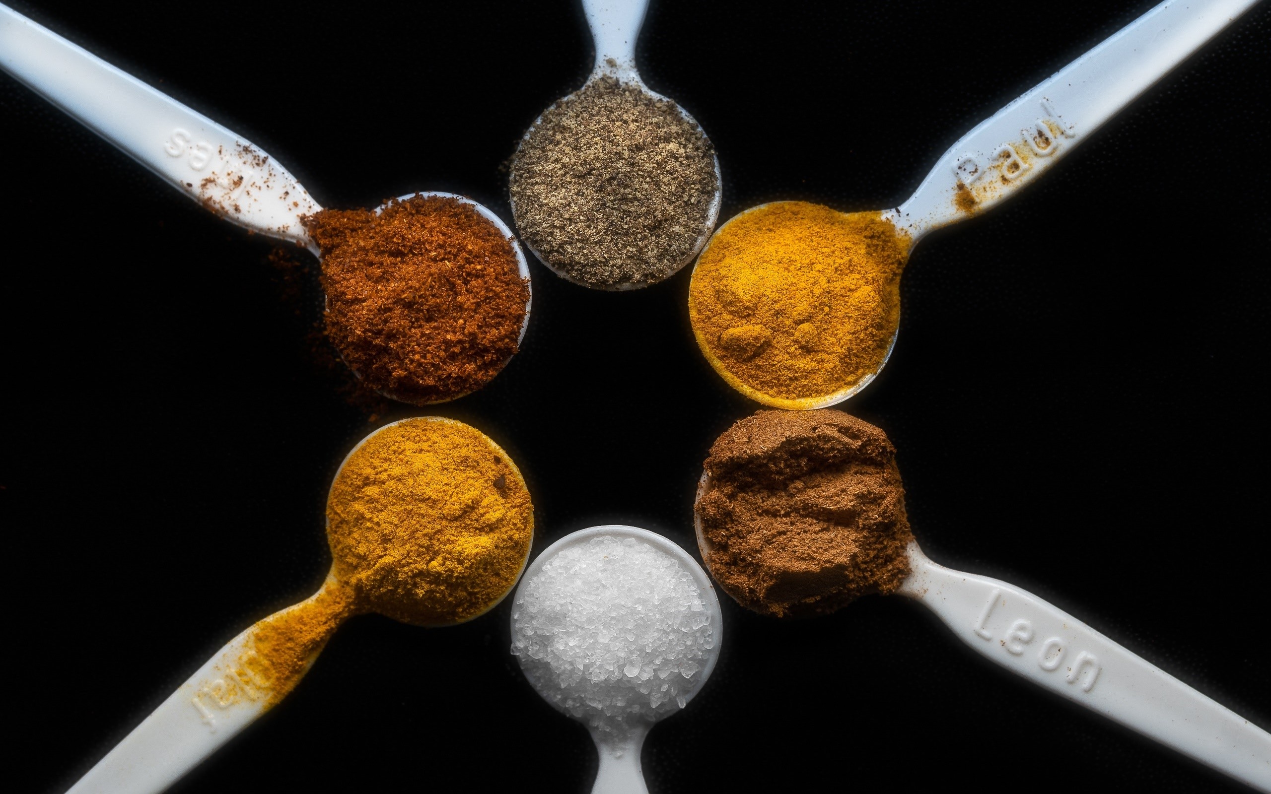 Spoons filled with various spices arranged in a circle HD Wallpaper