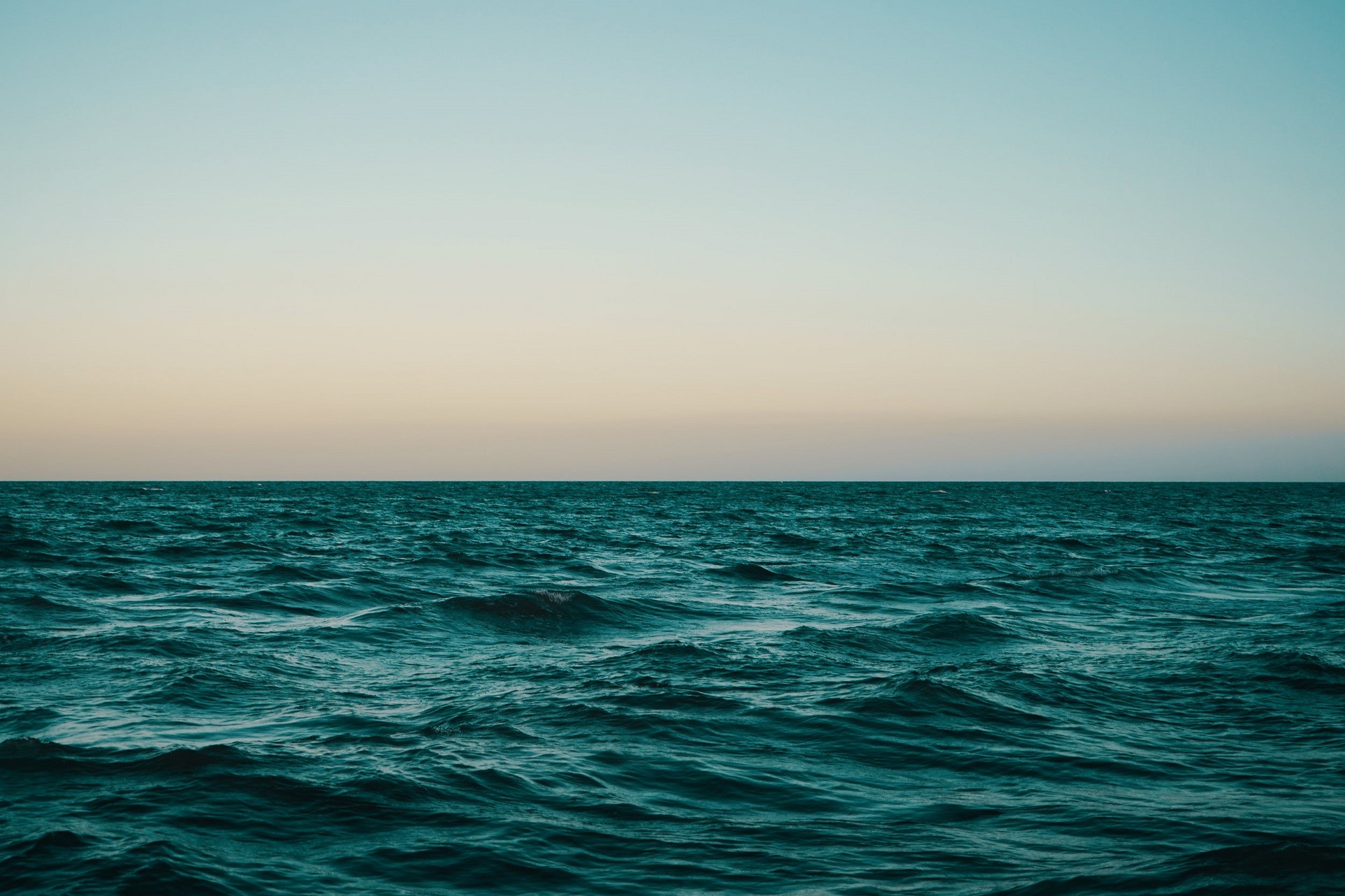Ocean horizon at dusk with gentle waves HD Wallpaper