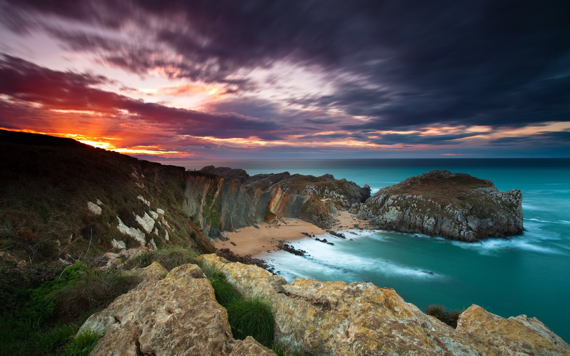 Sunset over a rocky coastline with turquoise ocean HD Wallpaper