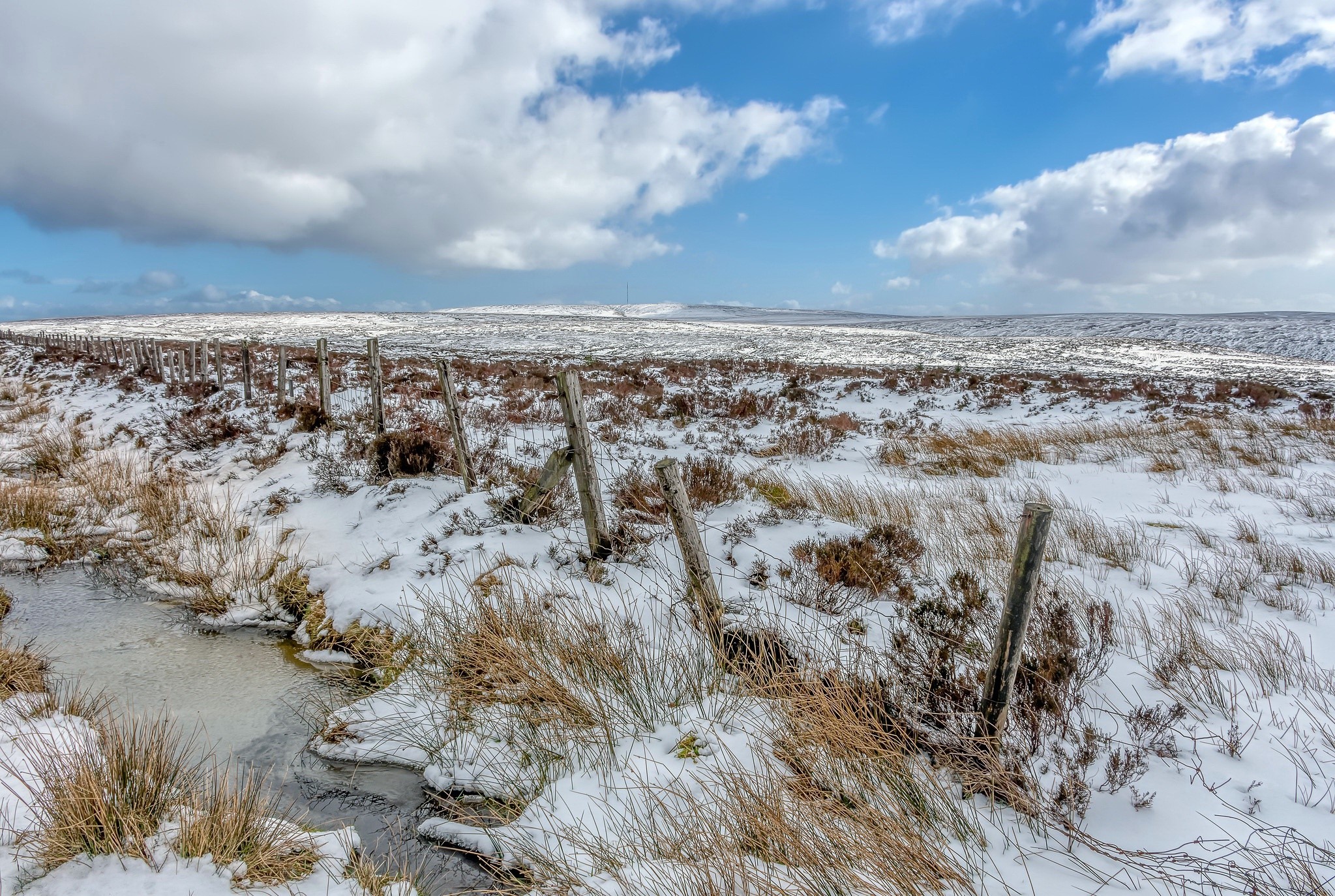 Winter landscape with snow-covered ground and a wooden fence HD Wallpaper