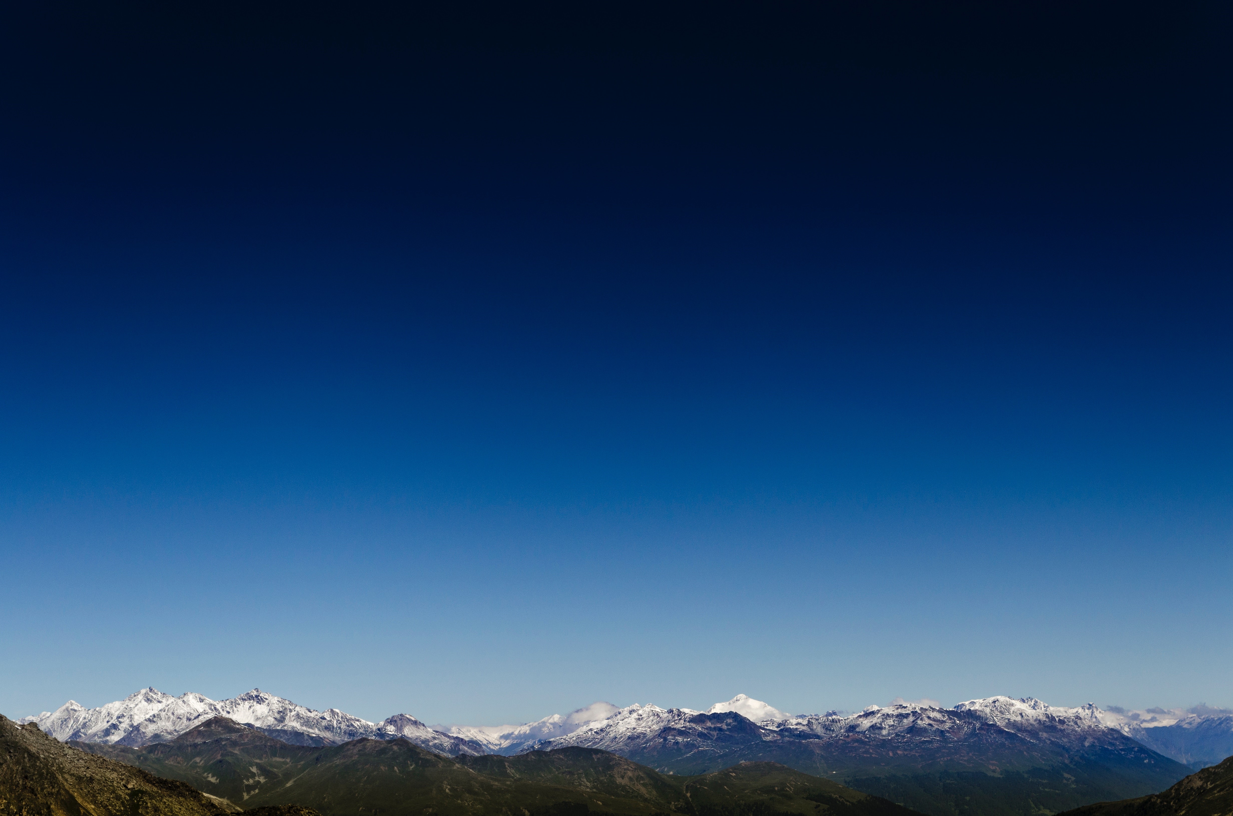 Snow-capped mountains under a clear blue sky HD Wallpaper