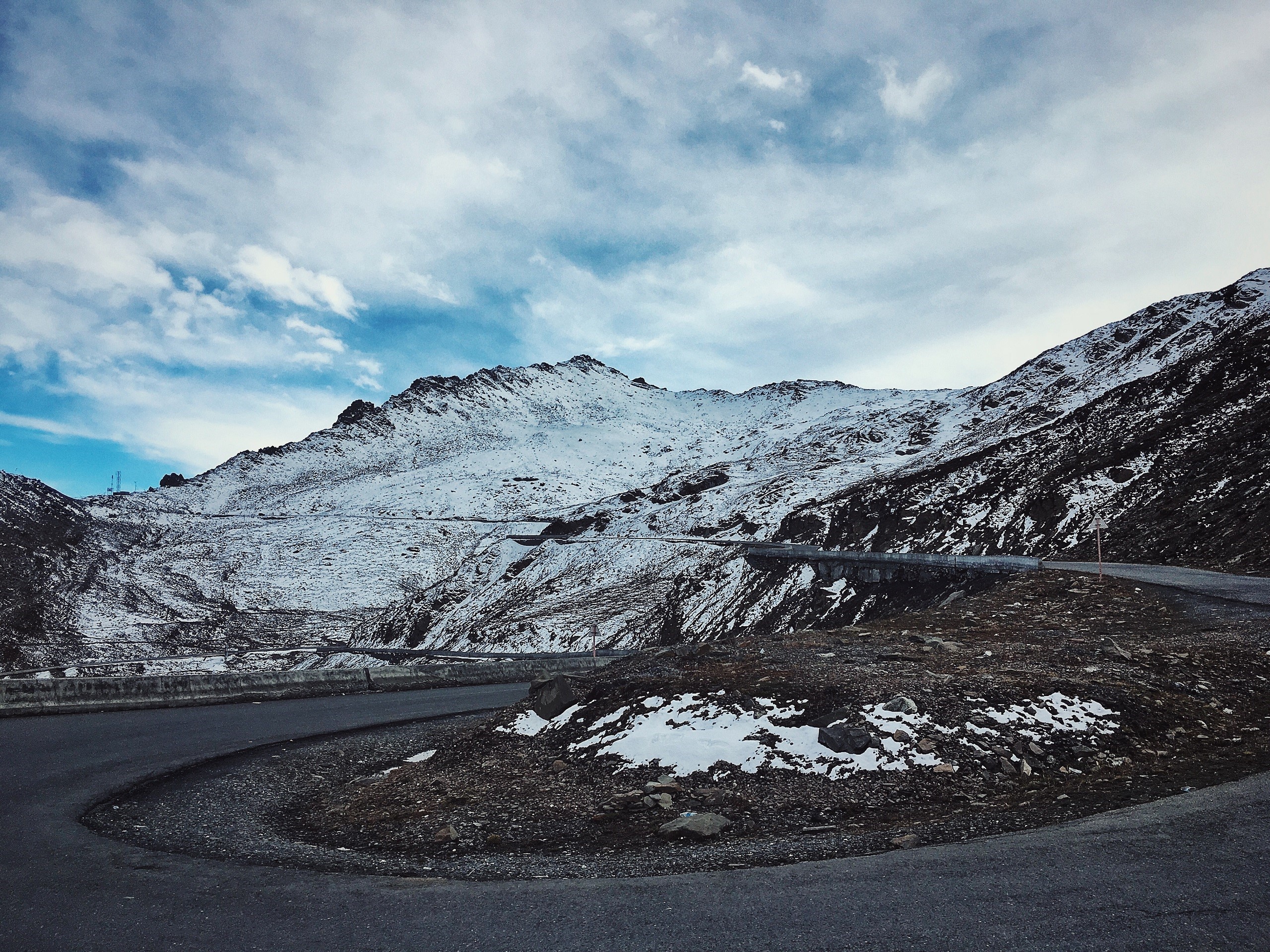 Snowy mountains with a winding road HD Wallpaper