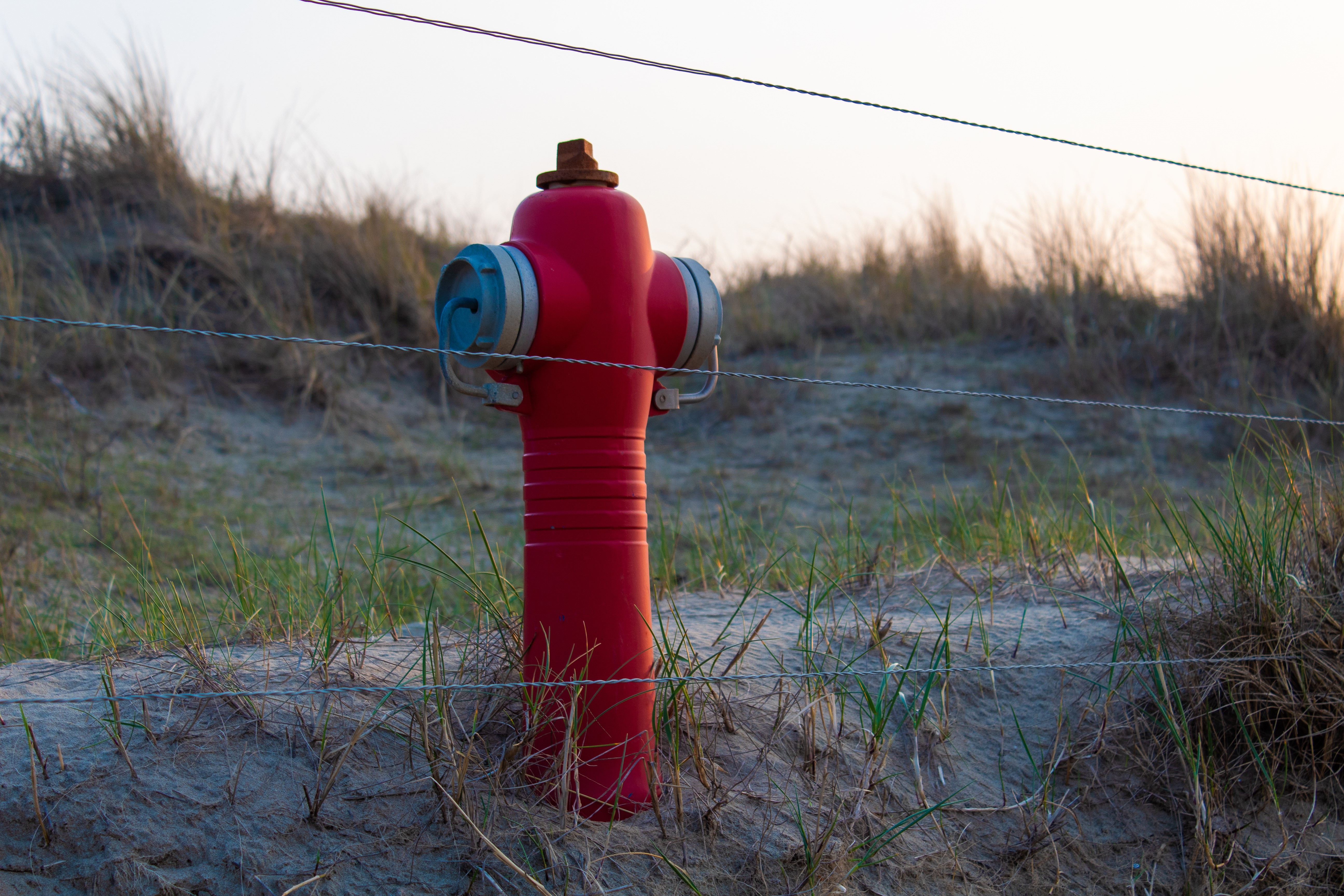 Red fire hydrant on sand dunes HD Wallpaper