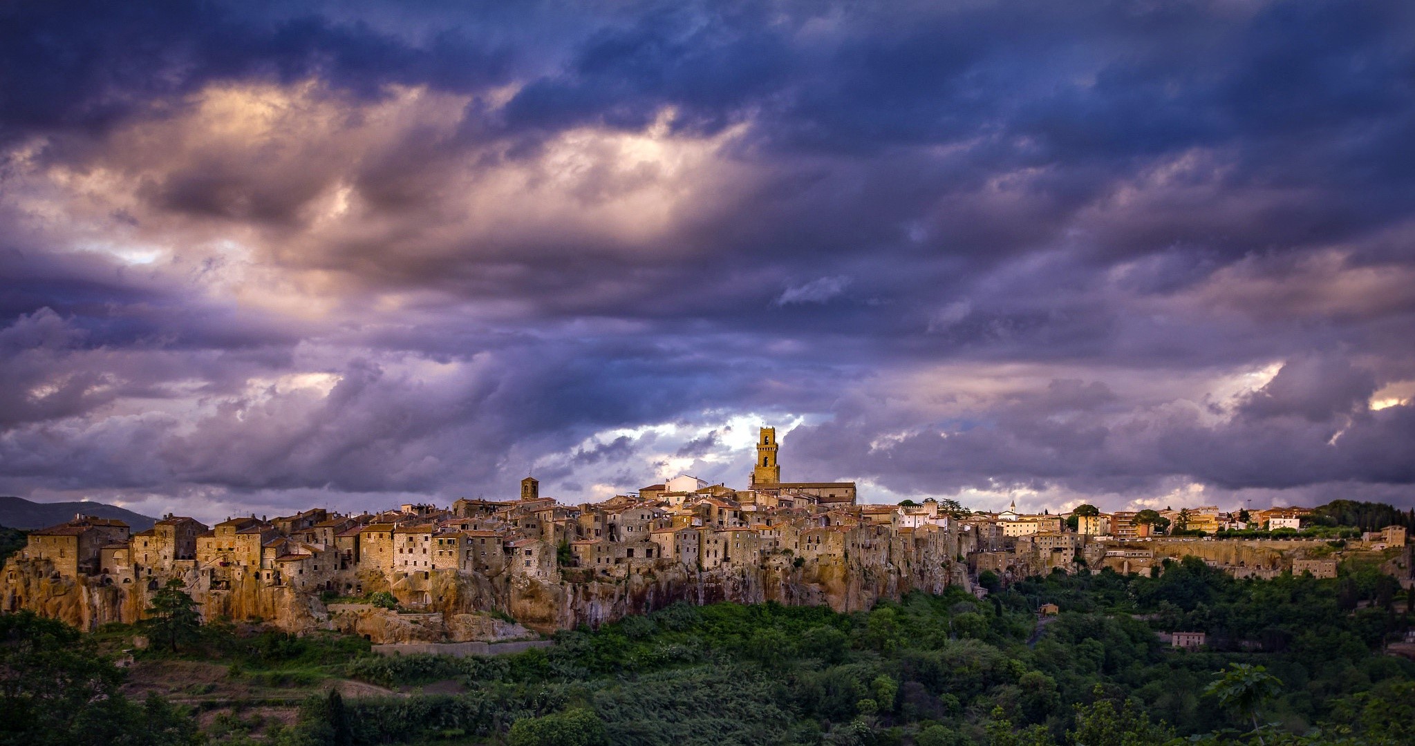 Pitigliano town in Tuscany, Italy under dramatic clouds HD Wallpaper