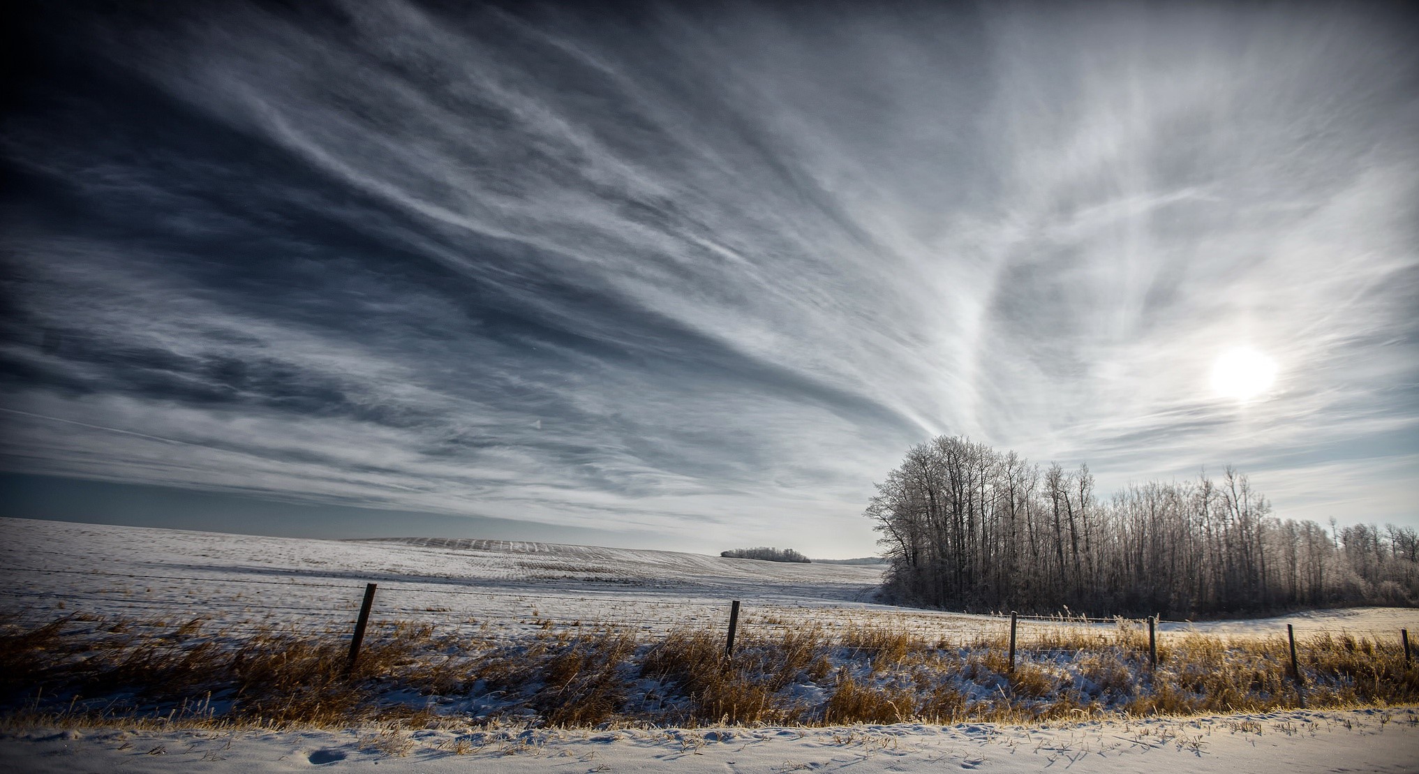 Winter landscape with snow-covered fields and dramatic clouds HD Wallpaper
