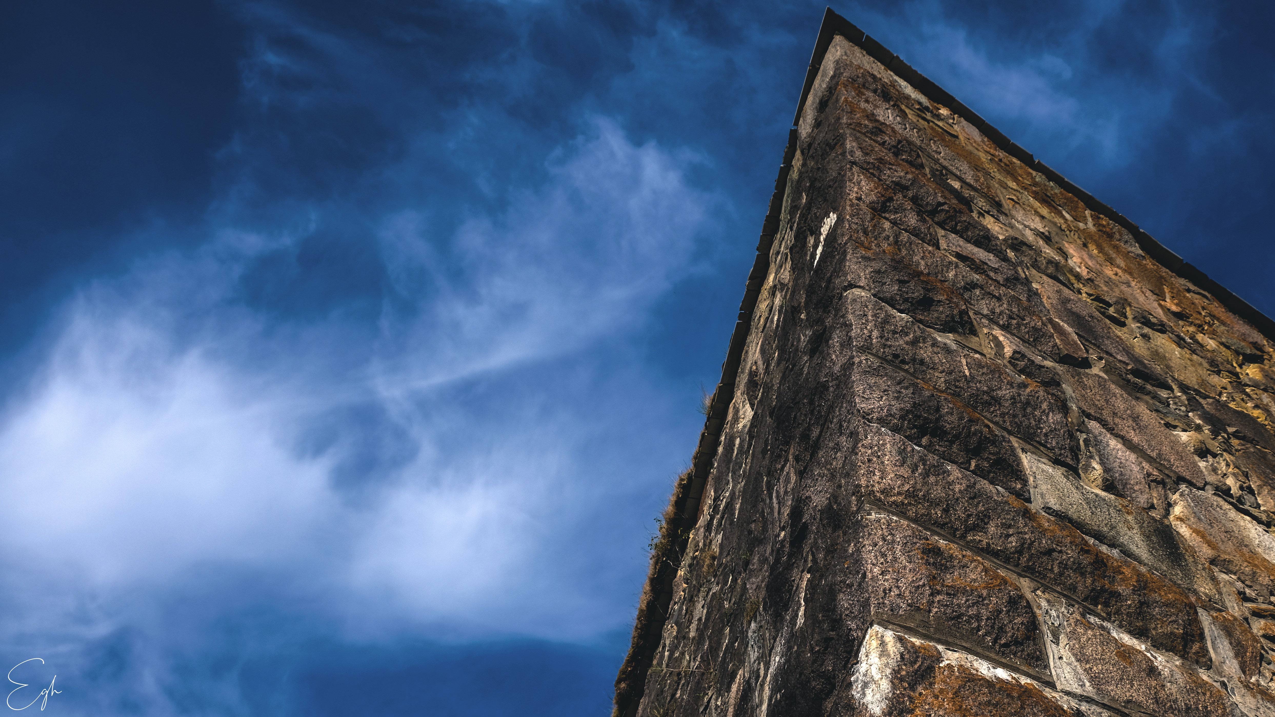 Old stone building corner against blue sky HD Wallpaper
