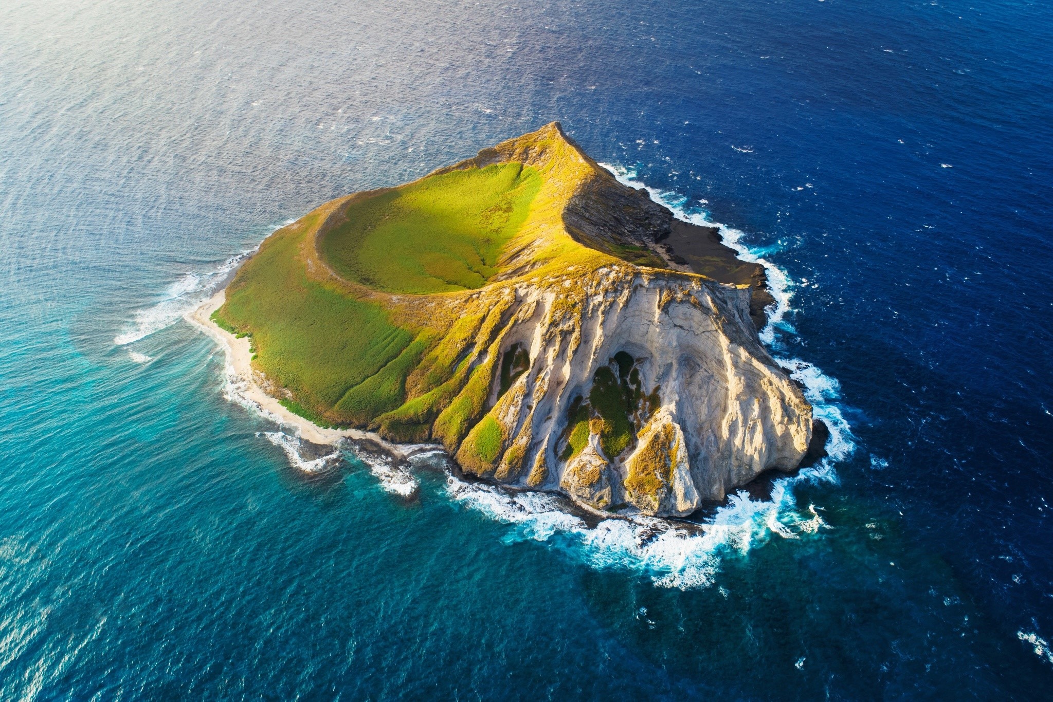 Aerial view of a green island surrounded by blue sea HD Wallpaper