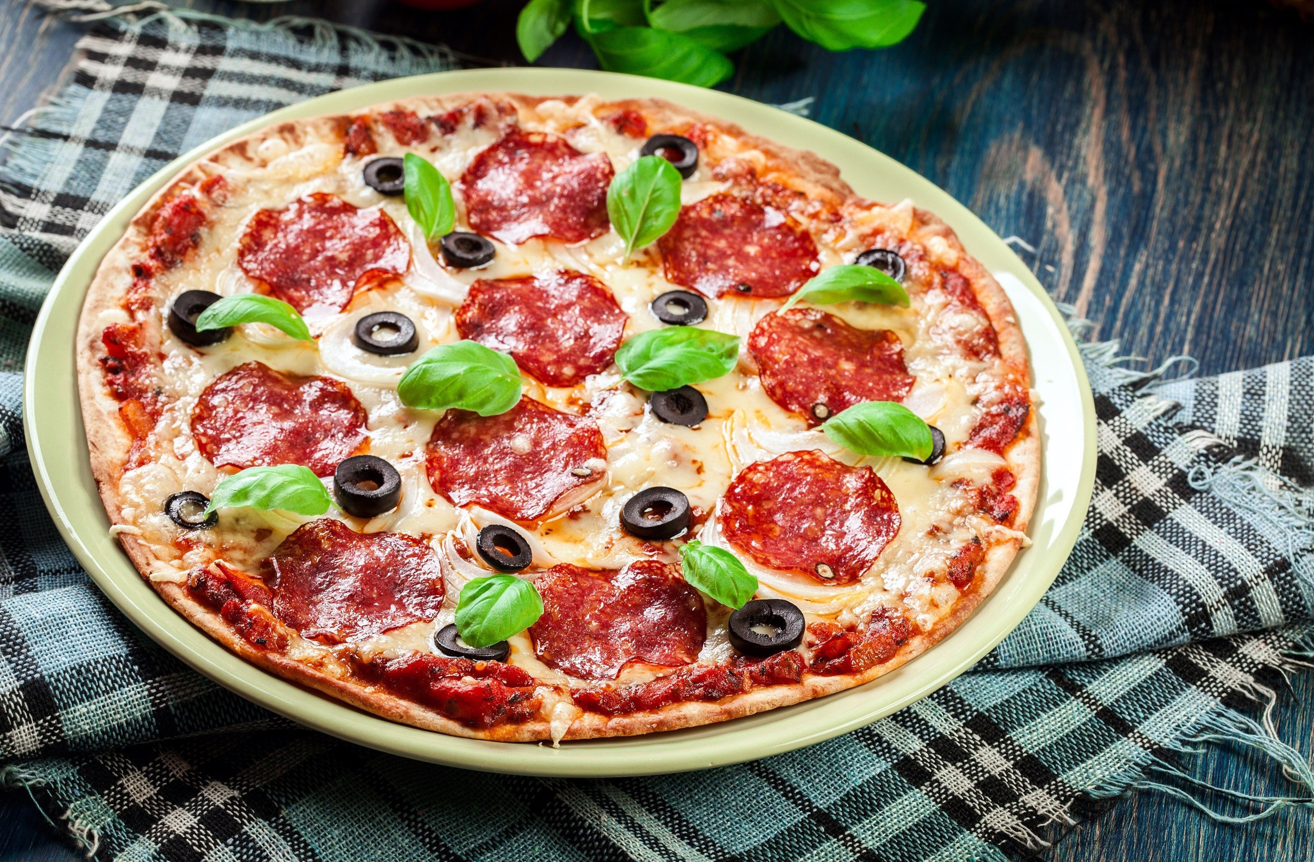 Pepperoni pizza with olives and basil on a plate HD Wallpaper