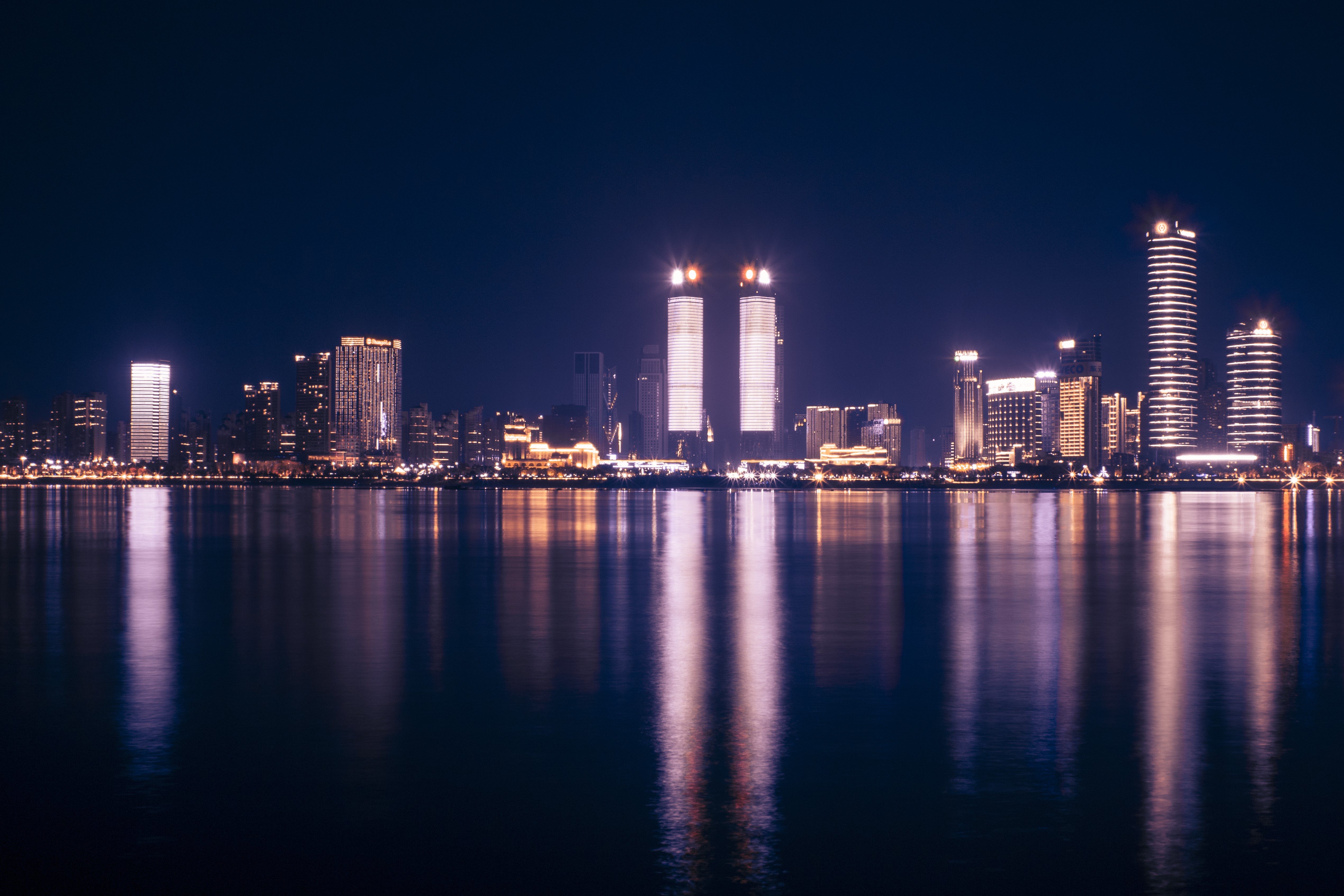City skyline reflected in water at night HD Wallpaper