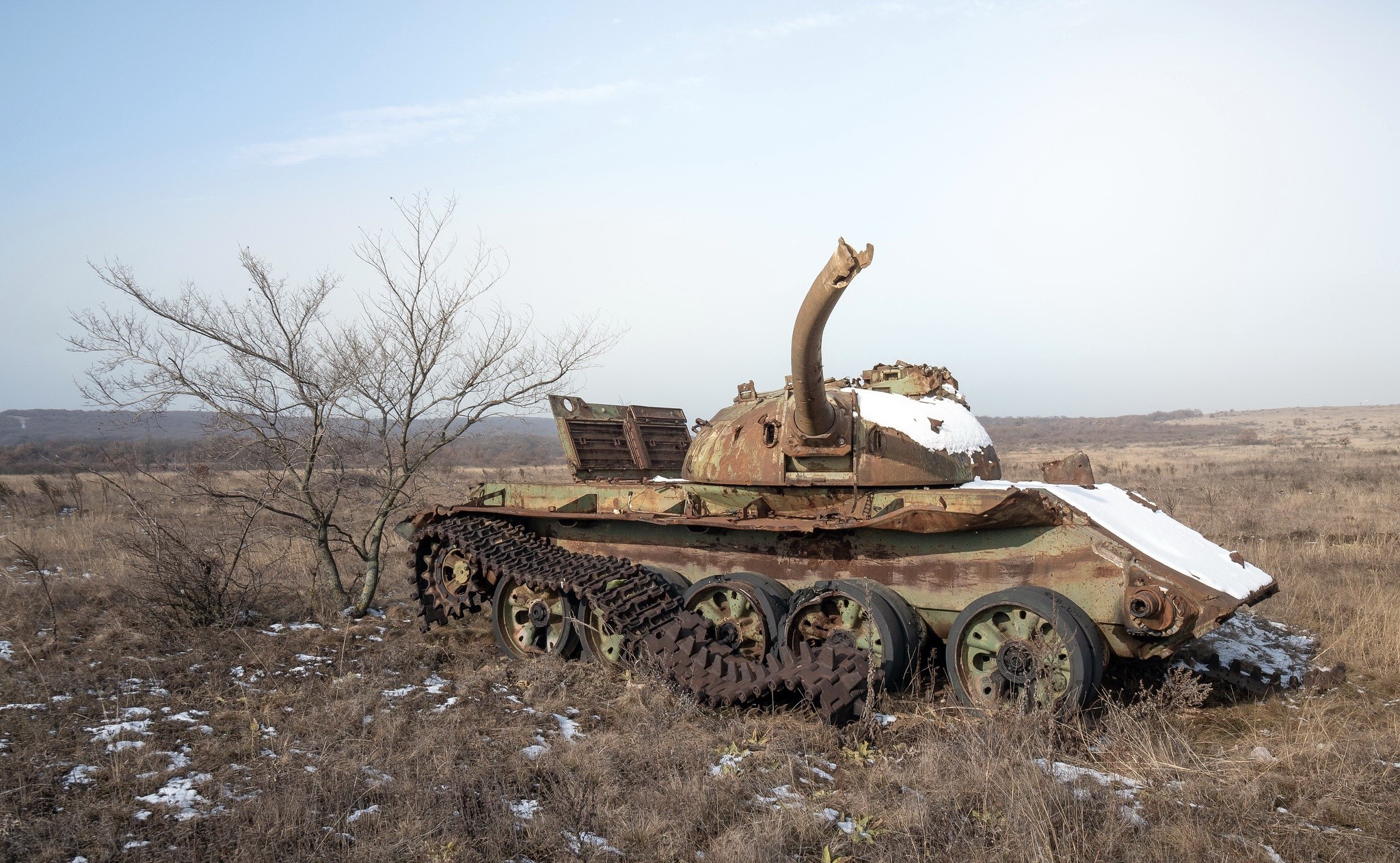 Abandoned tank wreck in a dry field with snow HD Wallpaper