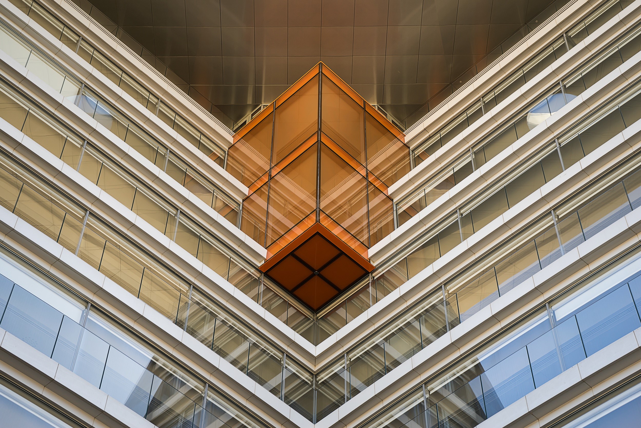 Modern building with glass facade and orange accent HD Wallpaper