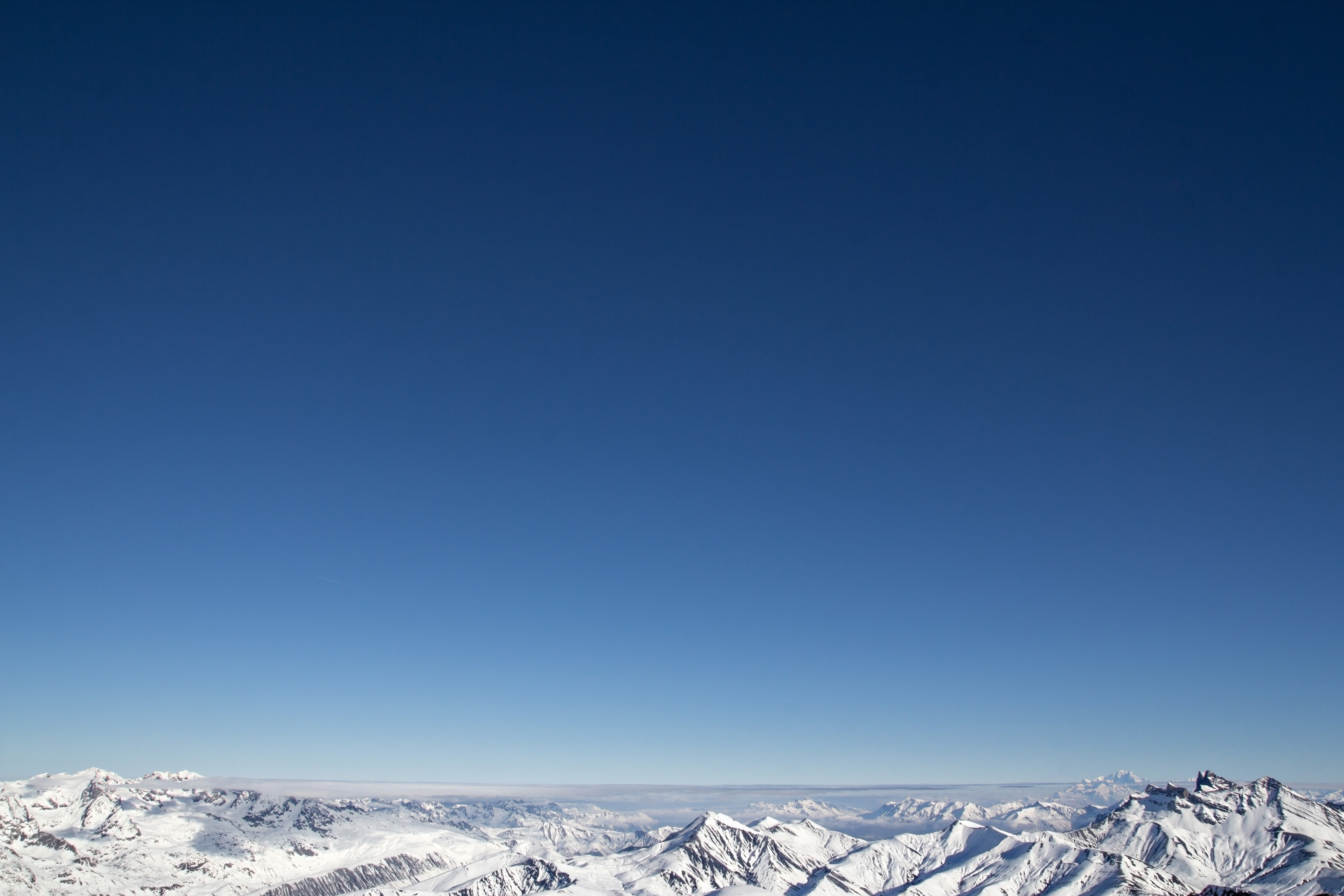 Snowy mountains under a clear blue sky HD Wallpaper