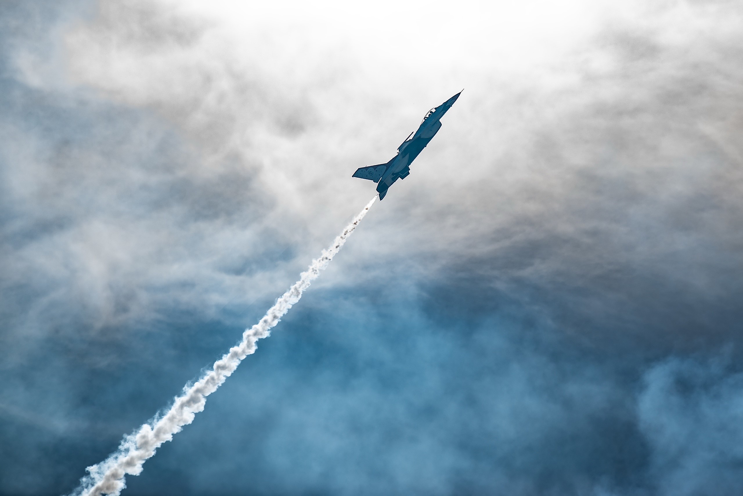 Military jet aircraft performing aerobatics with smoke trail HD Wallpaper