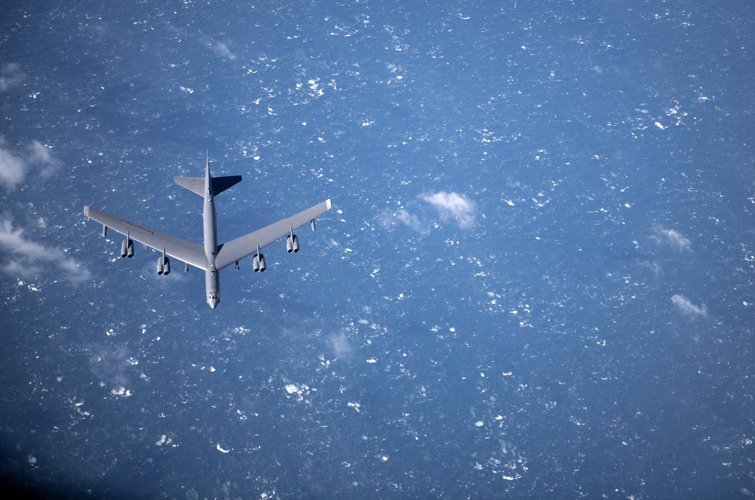 Boeing B-52 Stratofortress bomber flying over the ocean HD Wallpaper