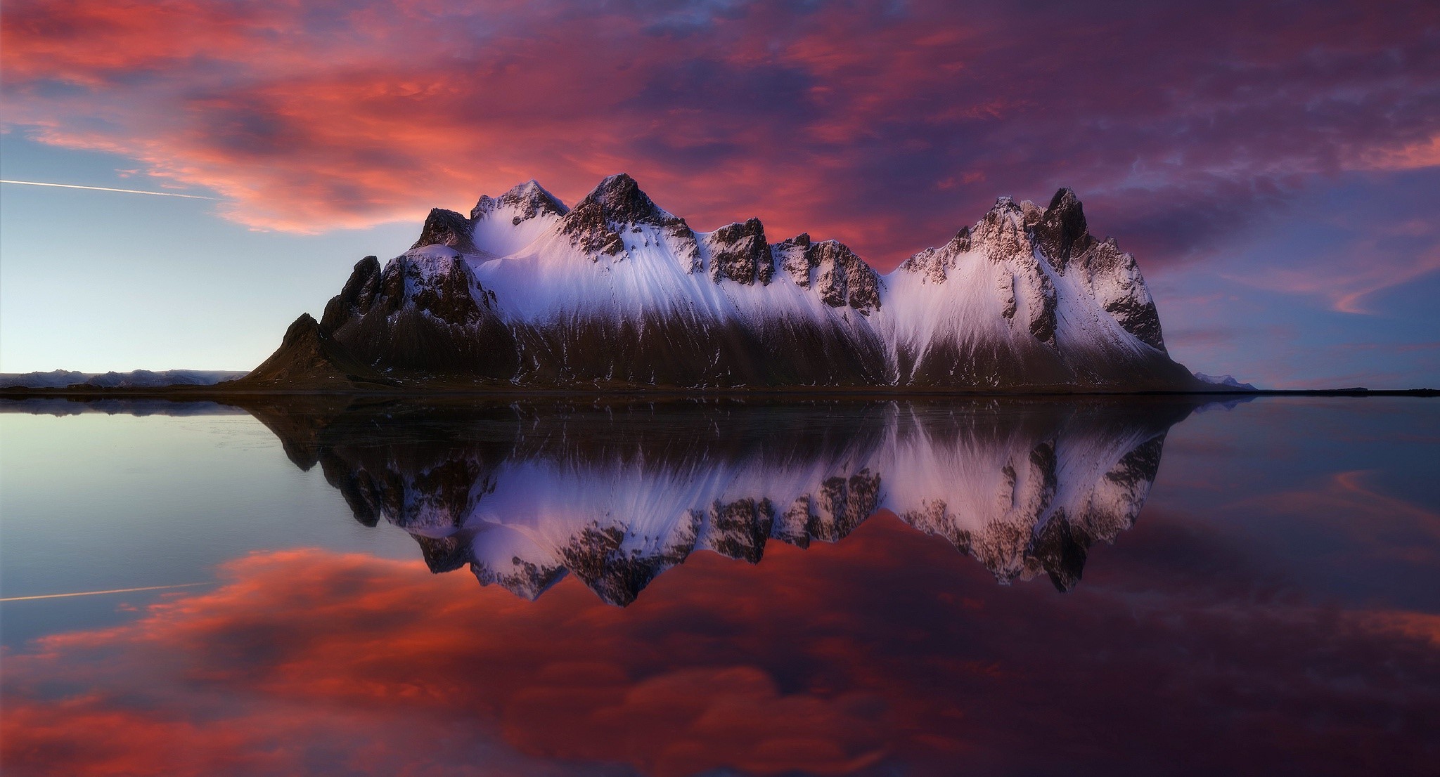 Snow-capped mountains reflected in calm water at sunset HD Wallpaper