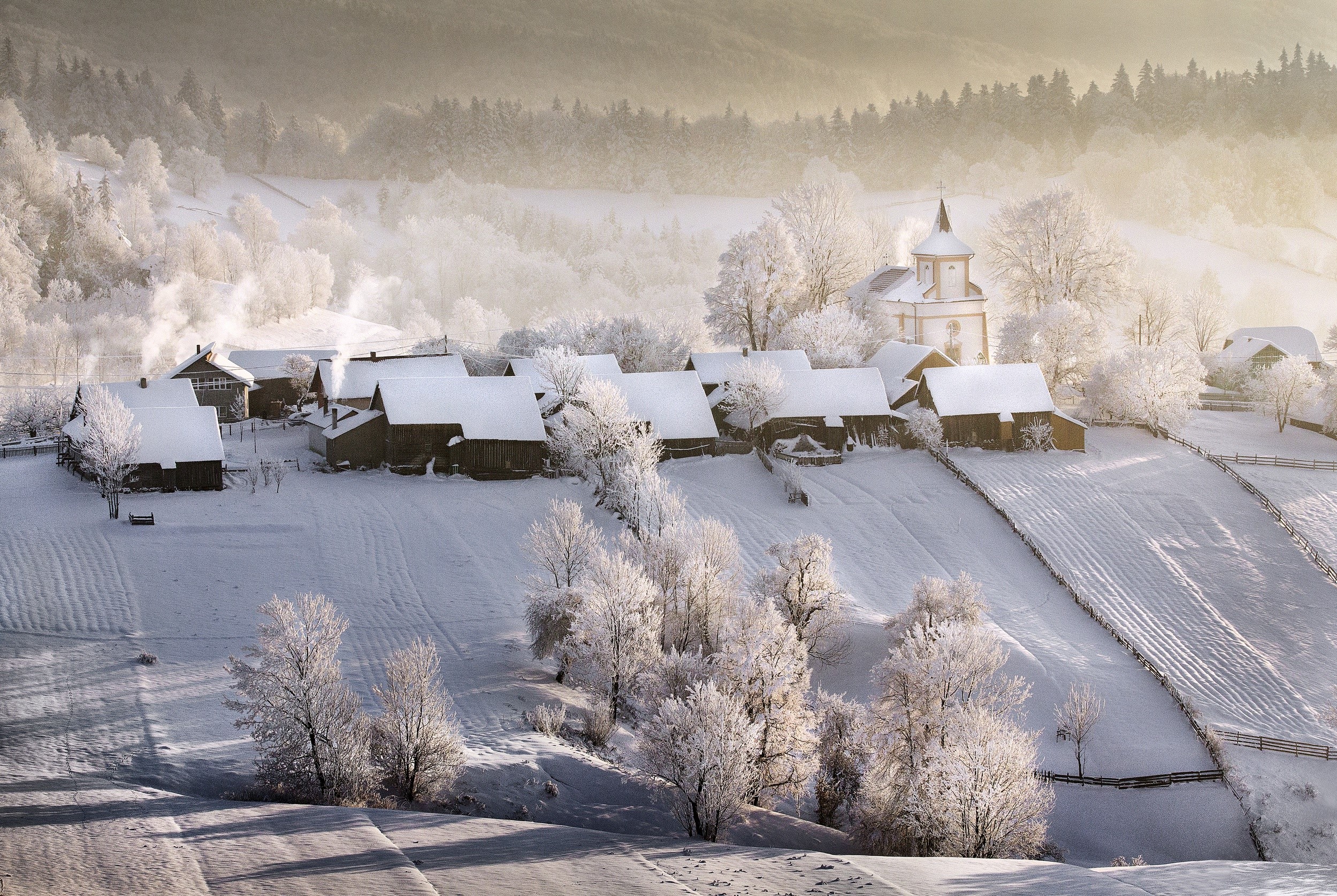 Snowy village with church in winter landscape HD Wallpaper