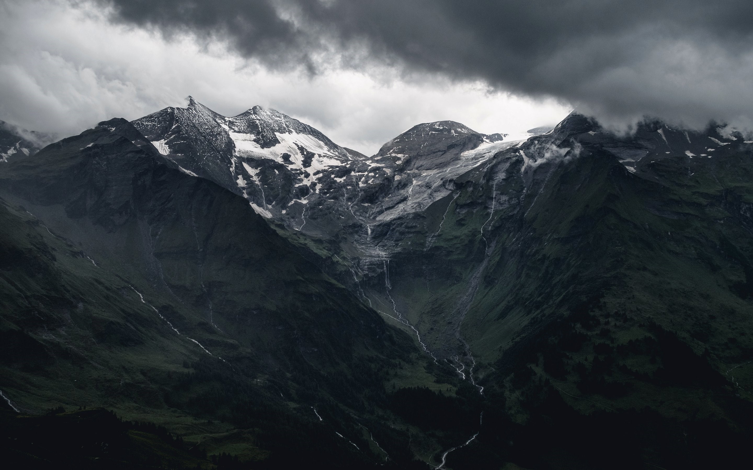 Dark stormy clouds over snow-capped mountains HD Wallpaper