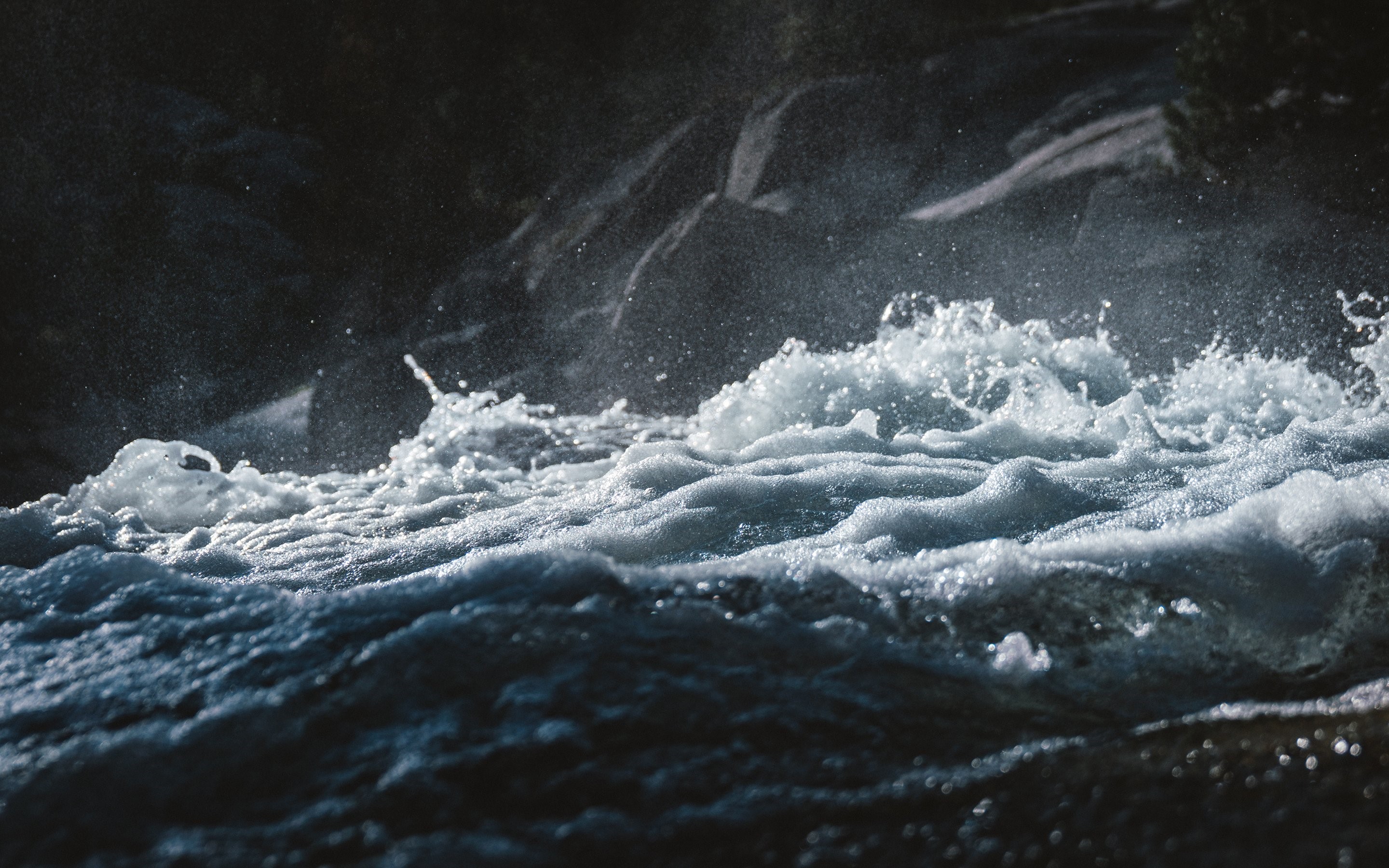 Close-up of turbulent water with rocks in background HD Wallpaper