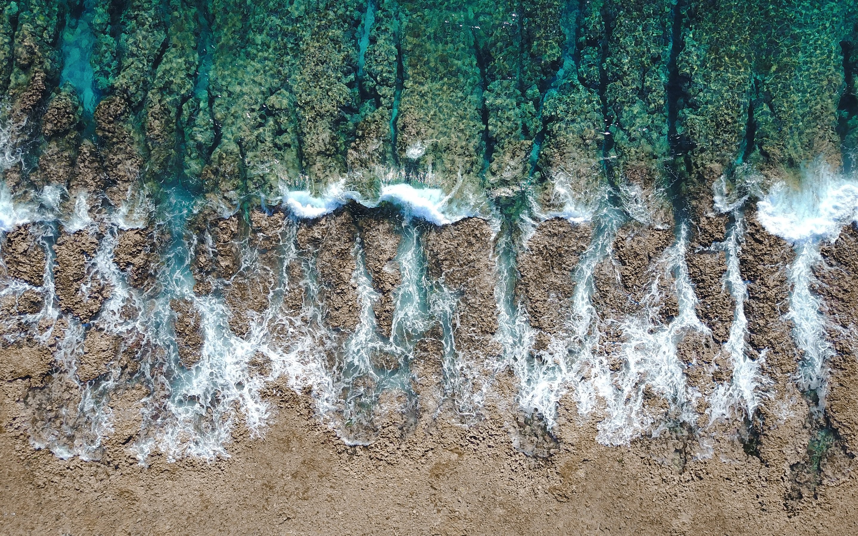 Aerial view of ocean waves crashing on rocky shore HD Wallpaper