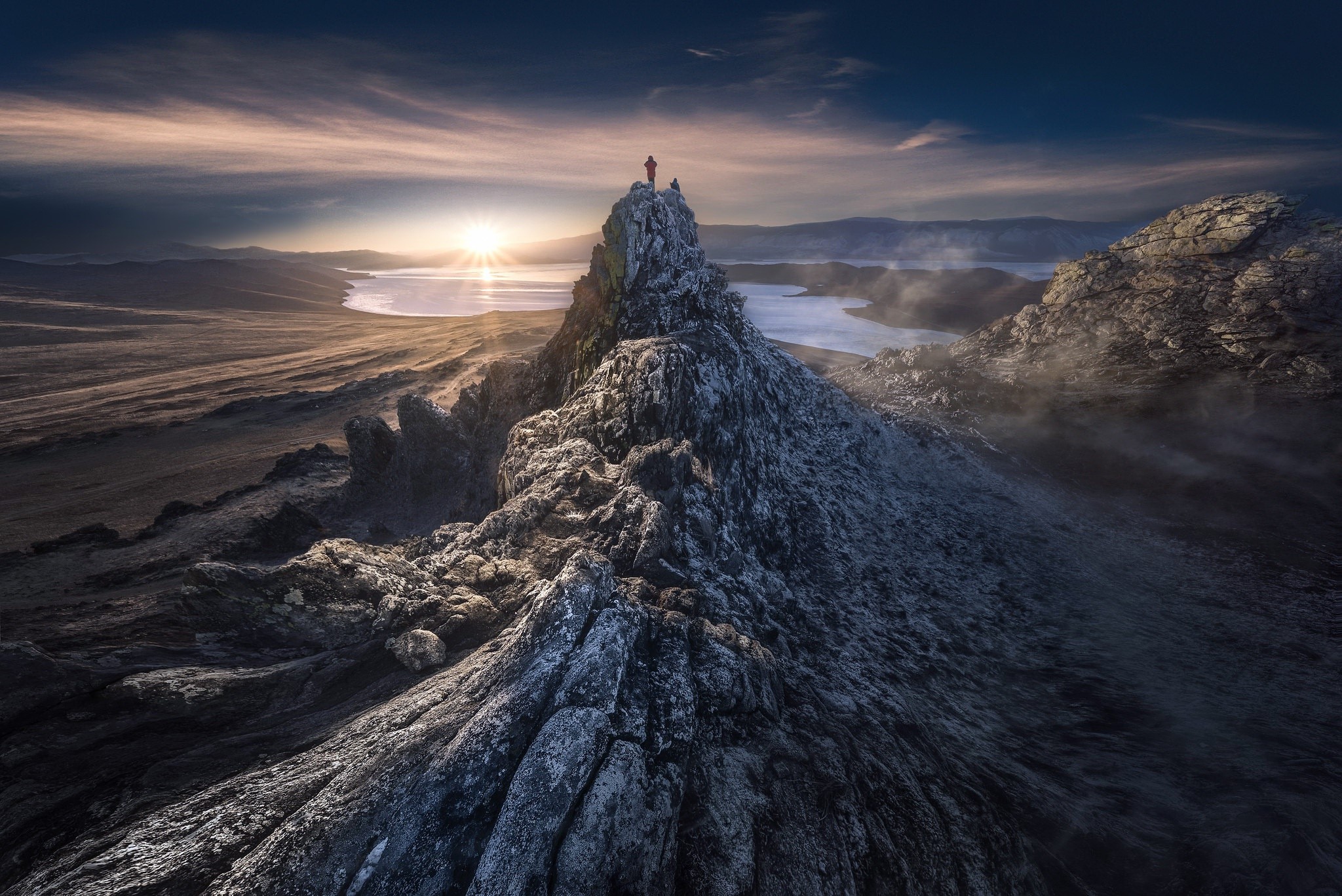 Two people on a rocky mountain peak at sunset HD Wallpaper