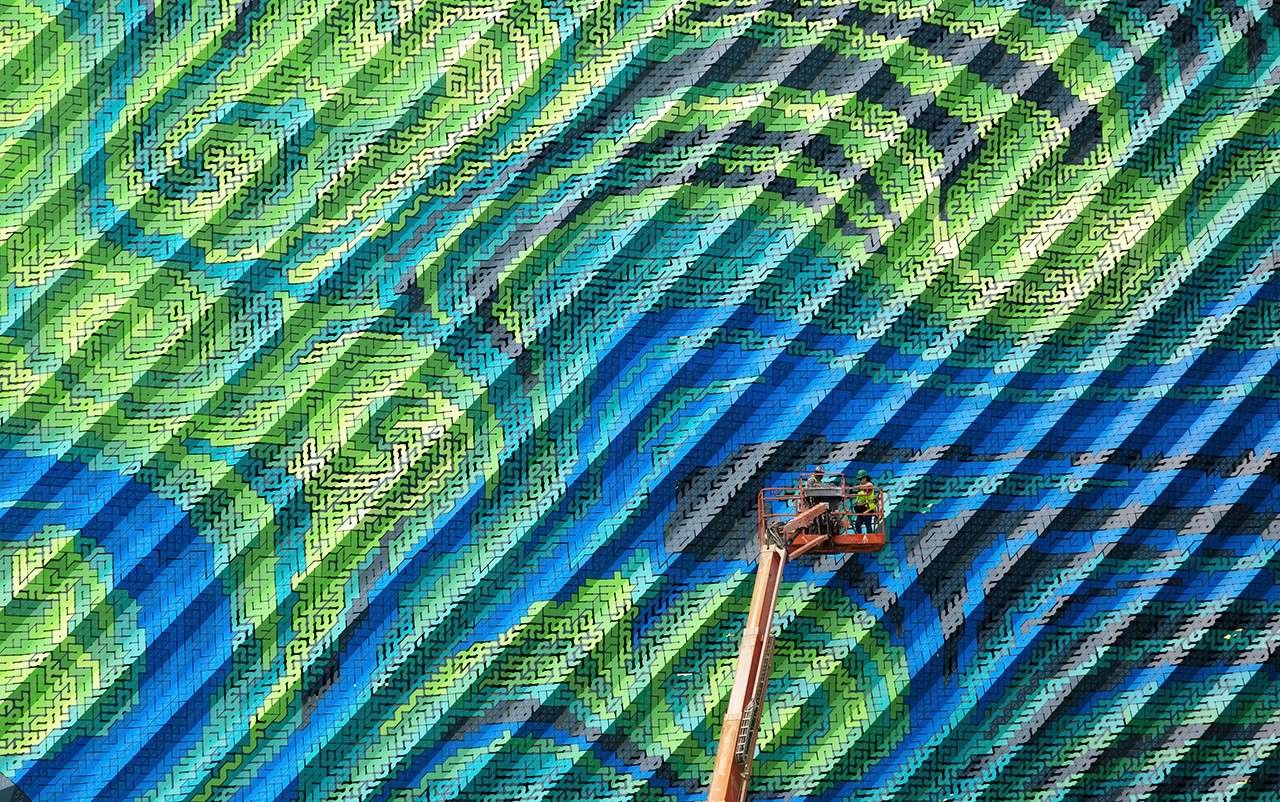 Workers on a lift painting a colorful mural HD Wallpaper
