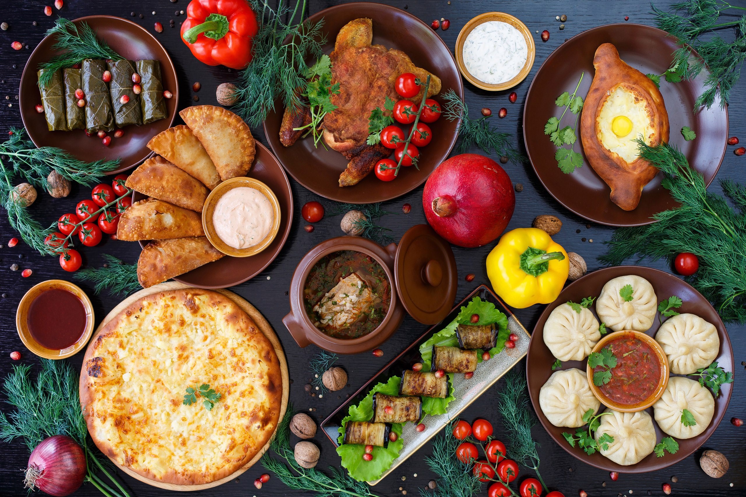 Georgian food spread with khachapuri, khinkali, and dolma HD Wallpaper