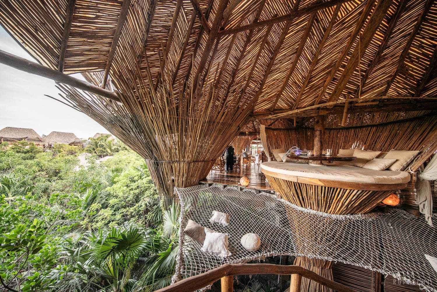 Tropical jungle treehouse with thatched roof and large bed HD Wallpaper