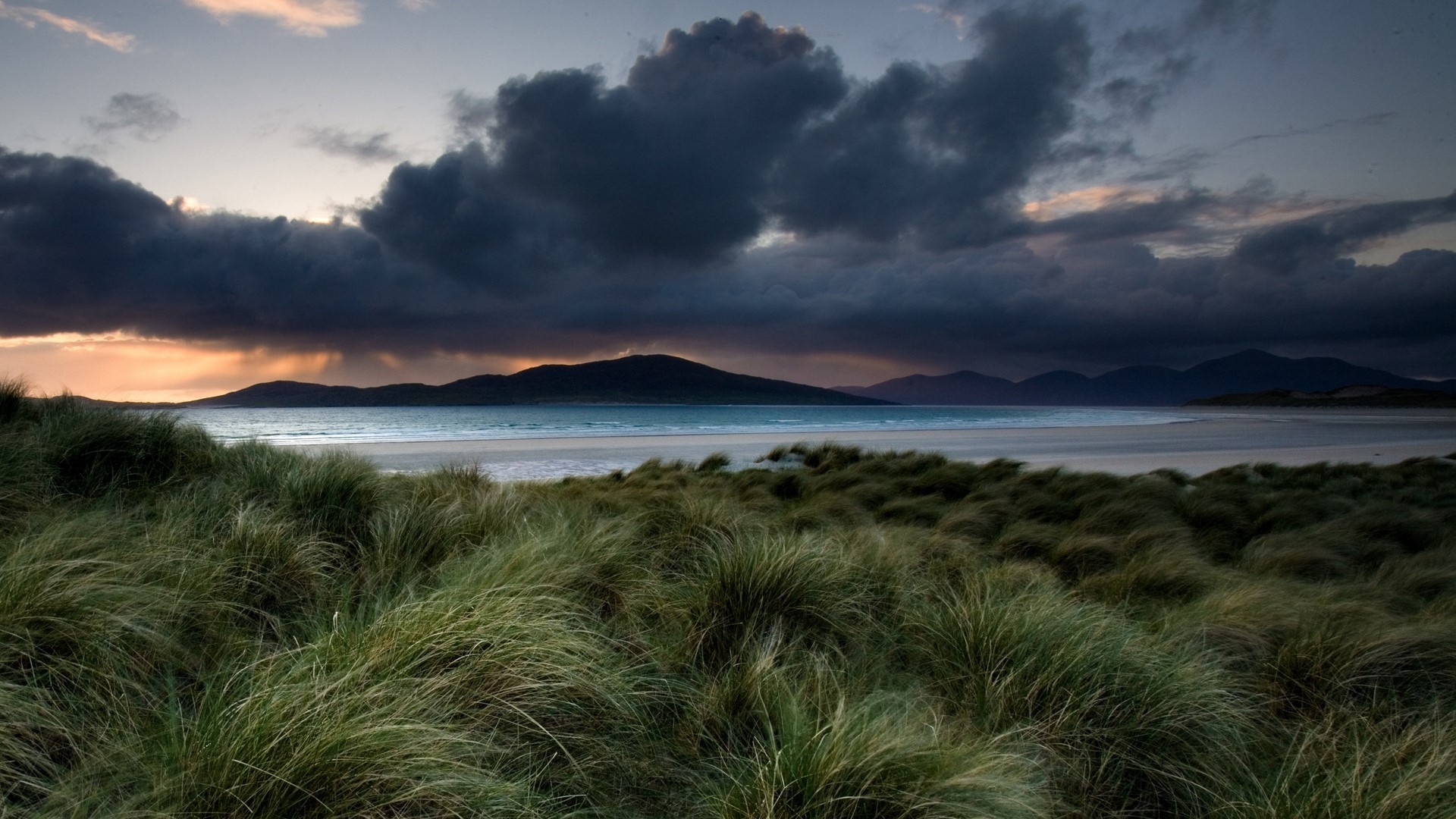 Stormy clouds over a beach with grass dunes HD Wallpaper