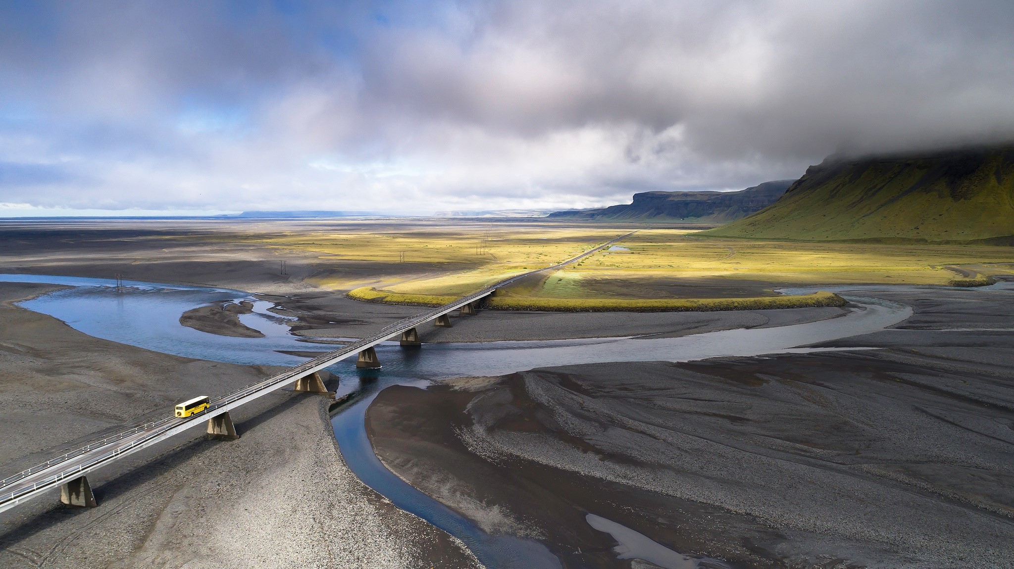 Yellow bus crossing a bridge over a river in Iceland HD Wallpaper
