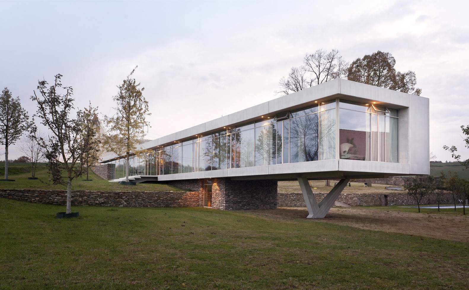 Modern concrete house with glass walls on stilts HD Wallpaper