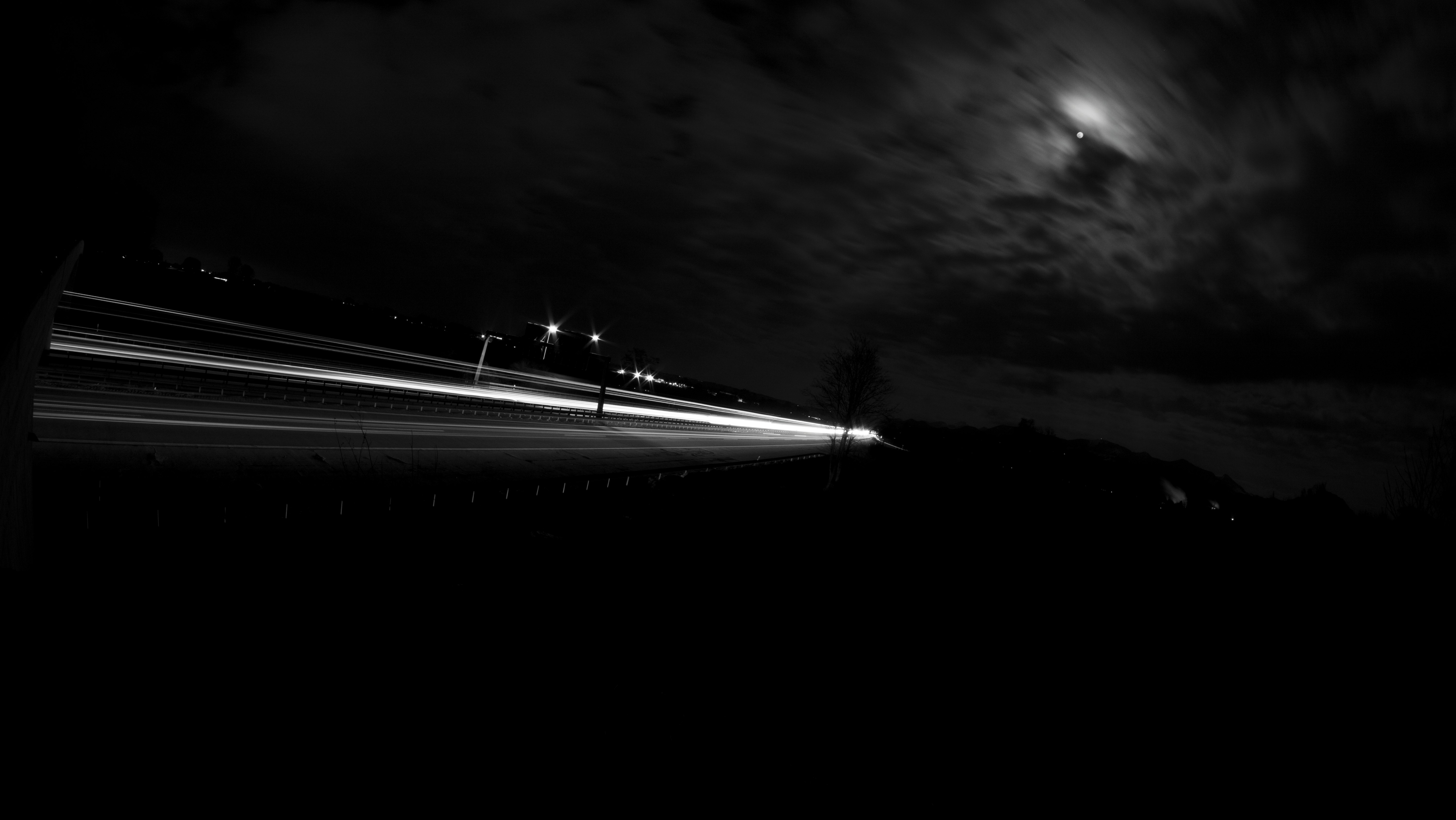 Long exposure of a highway at night with moon and clouds HD Wallpaper