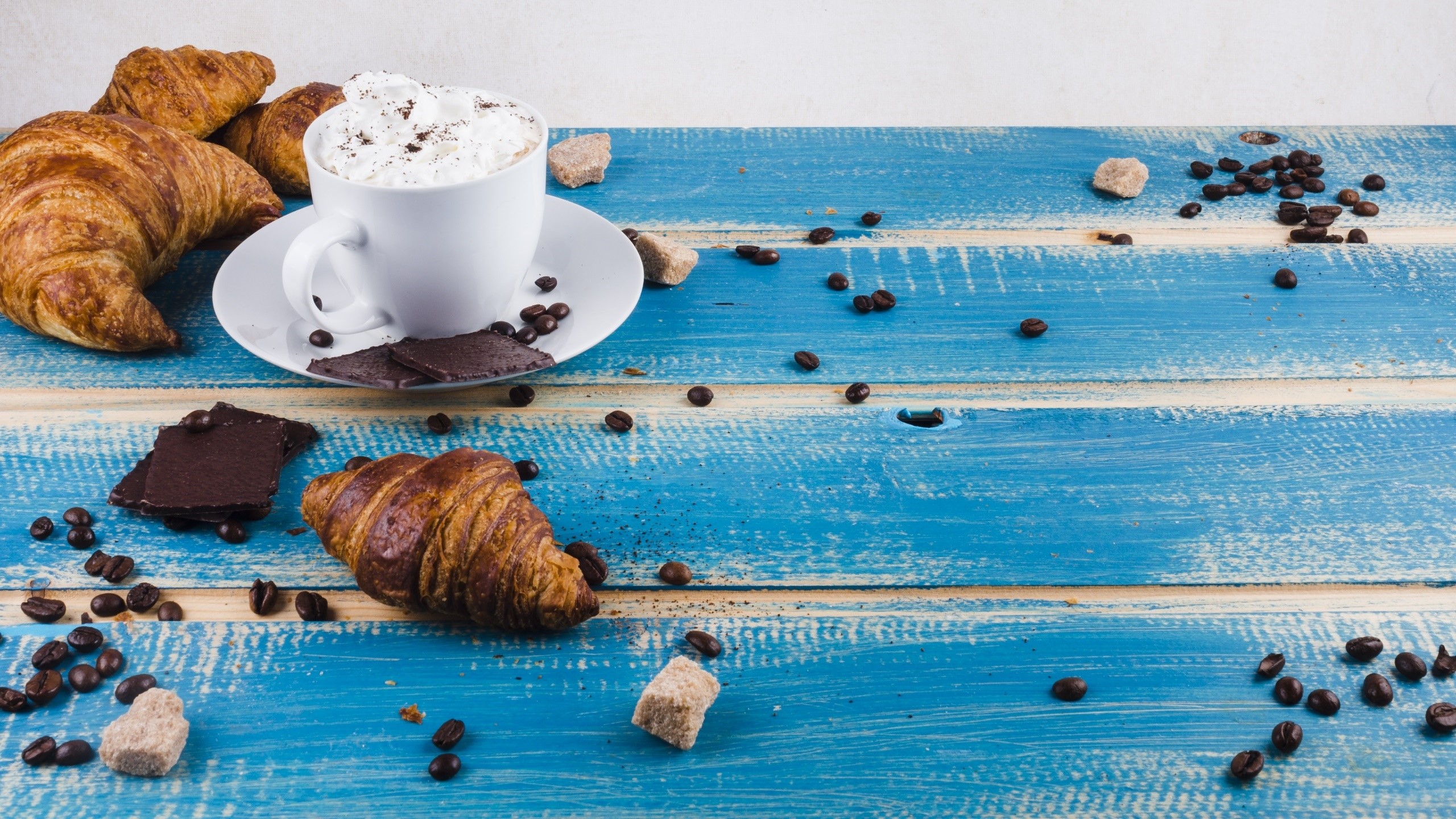 Croissants, coffee, chocolate, and sugar cubes on a blue table HD Wallpaper