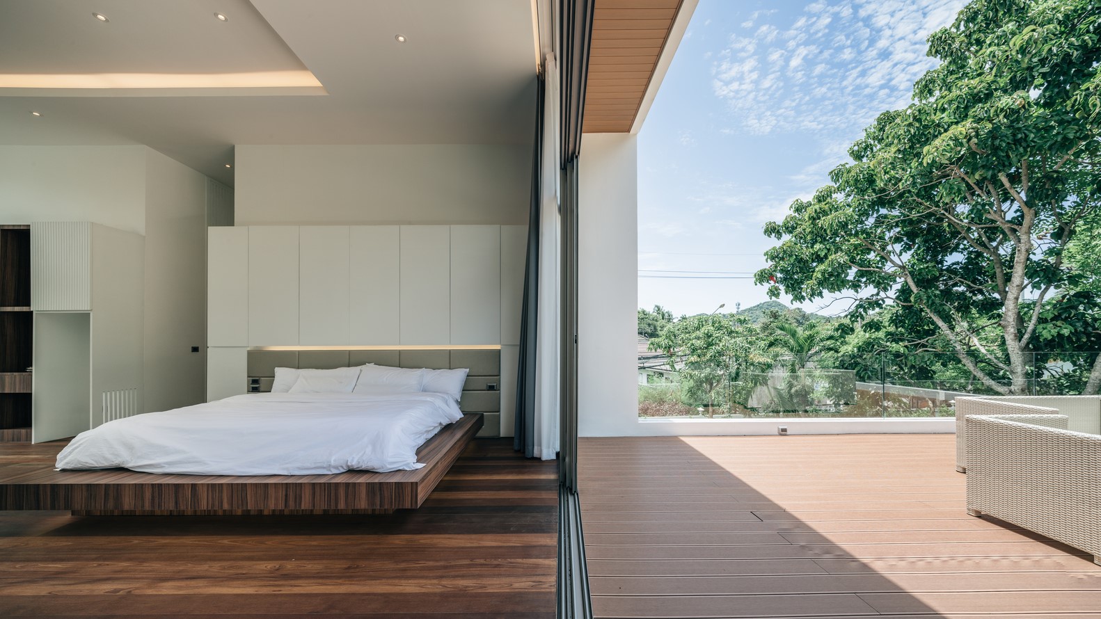 Modern bedroom with a large bed and balcony view HD Wallpaper