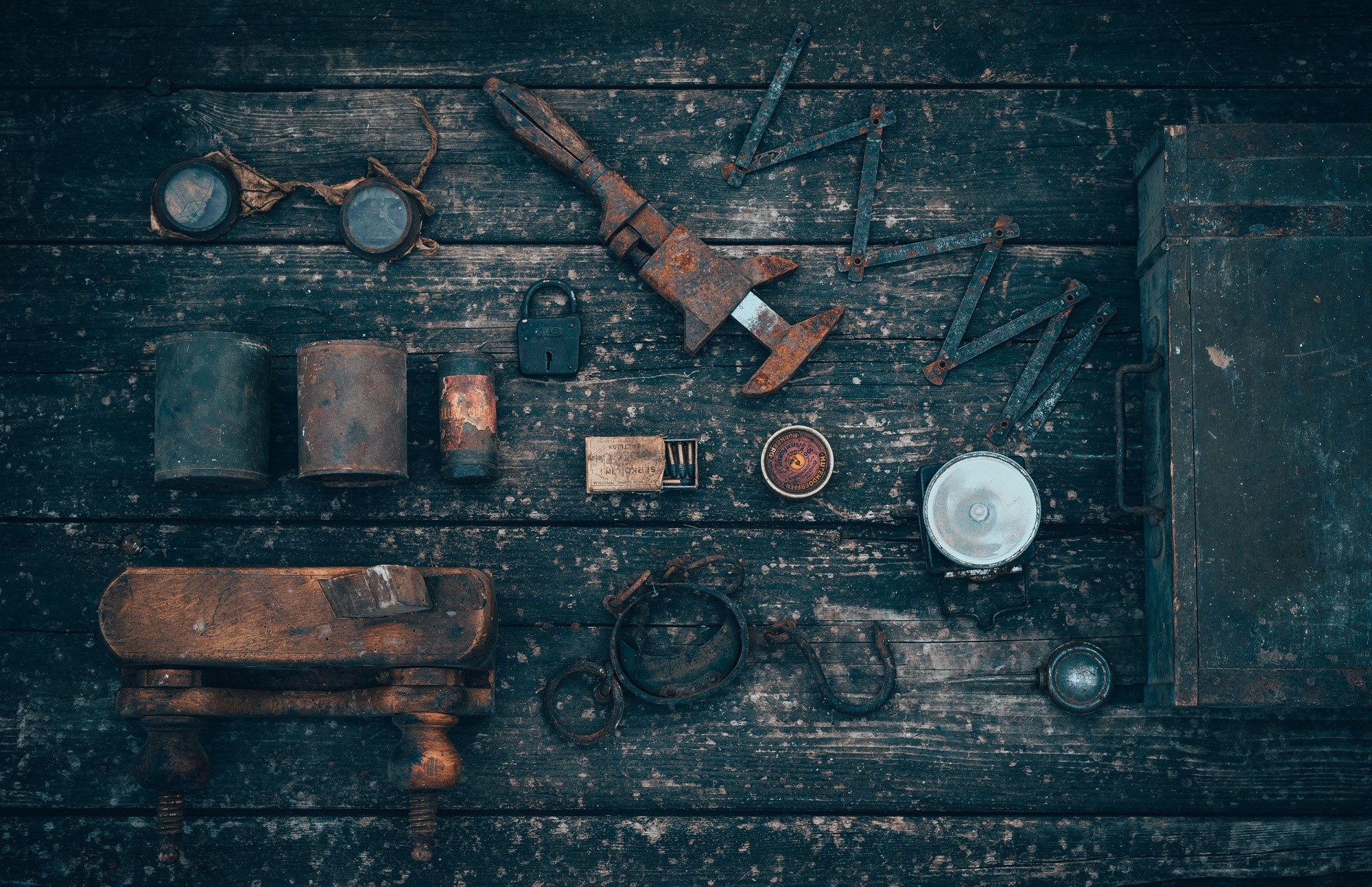 Collection of old rusty tools and items on a wooden surface HD Wallpaper