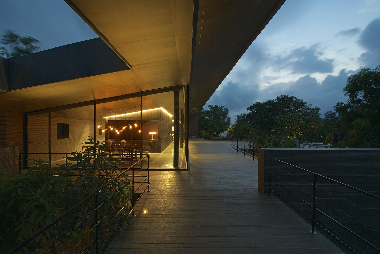 Modern house with glass walls and outdoor walkway at dusk HD Wallpaper