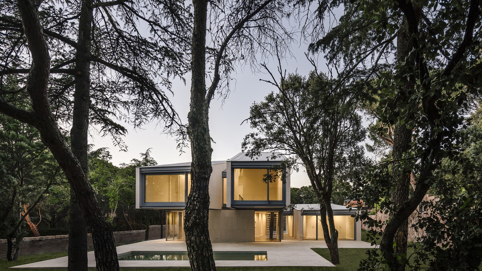 Modern house with swimming pool surrounded by trees HD Wallpaper