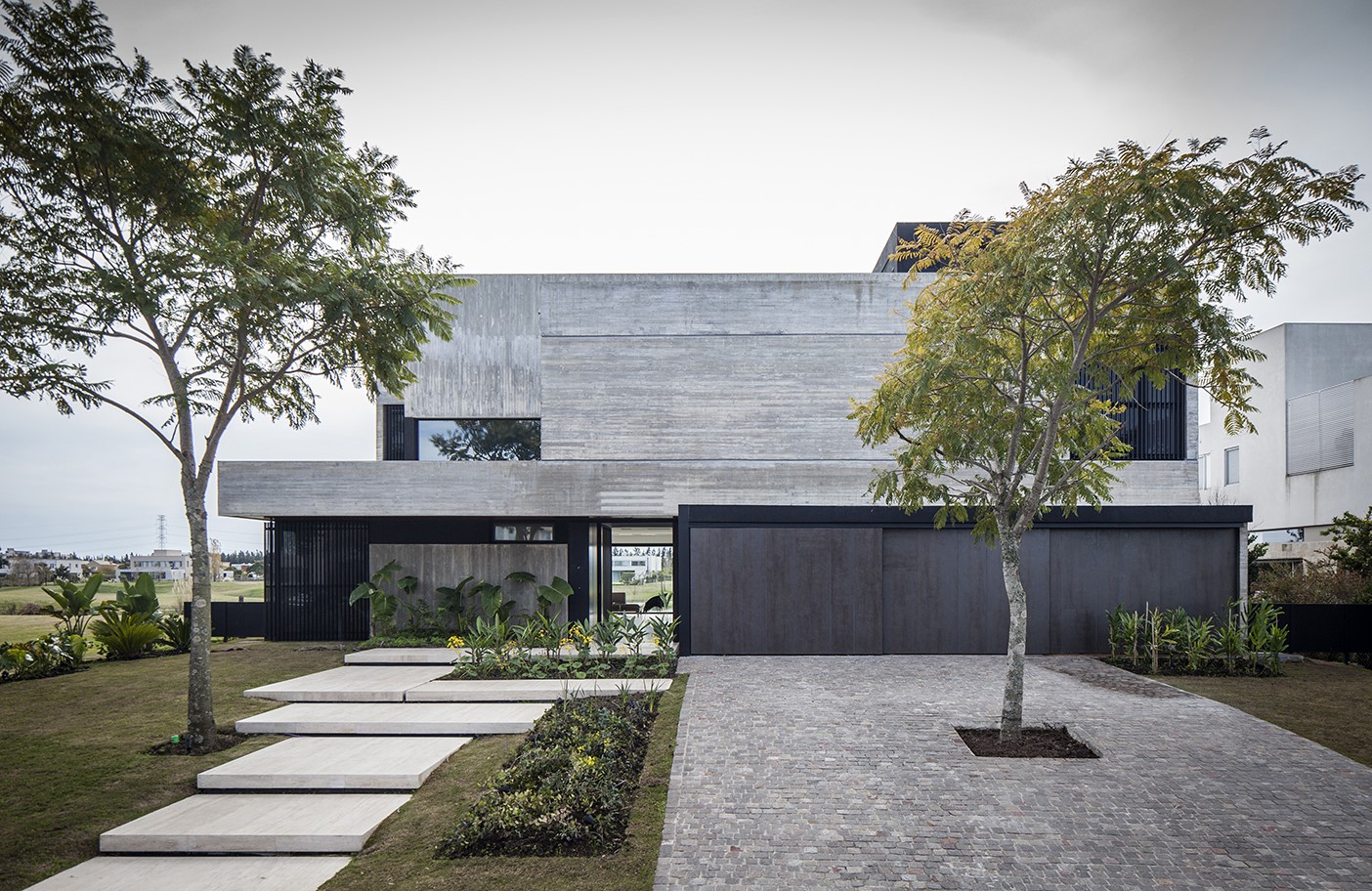 Modern concrete house with trees and stone pathway HD Wallpaper
