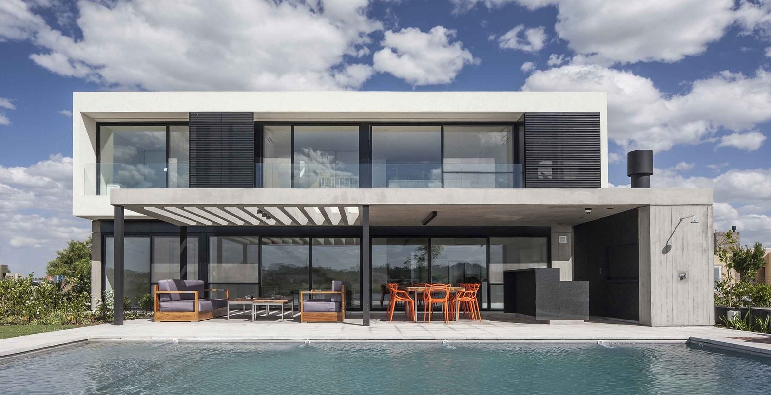 Modern house with swimming pool and outdoor dining area HD Wallpaper