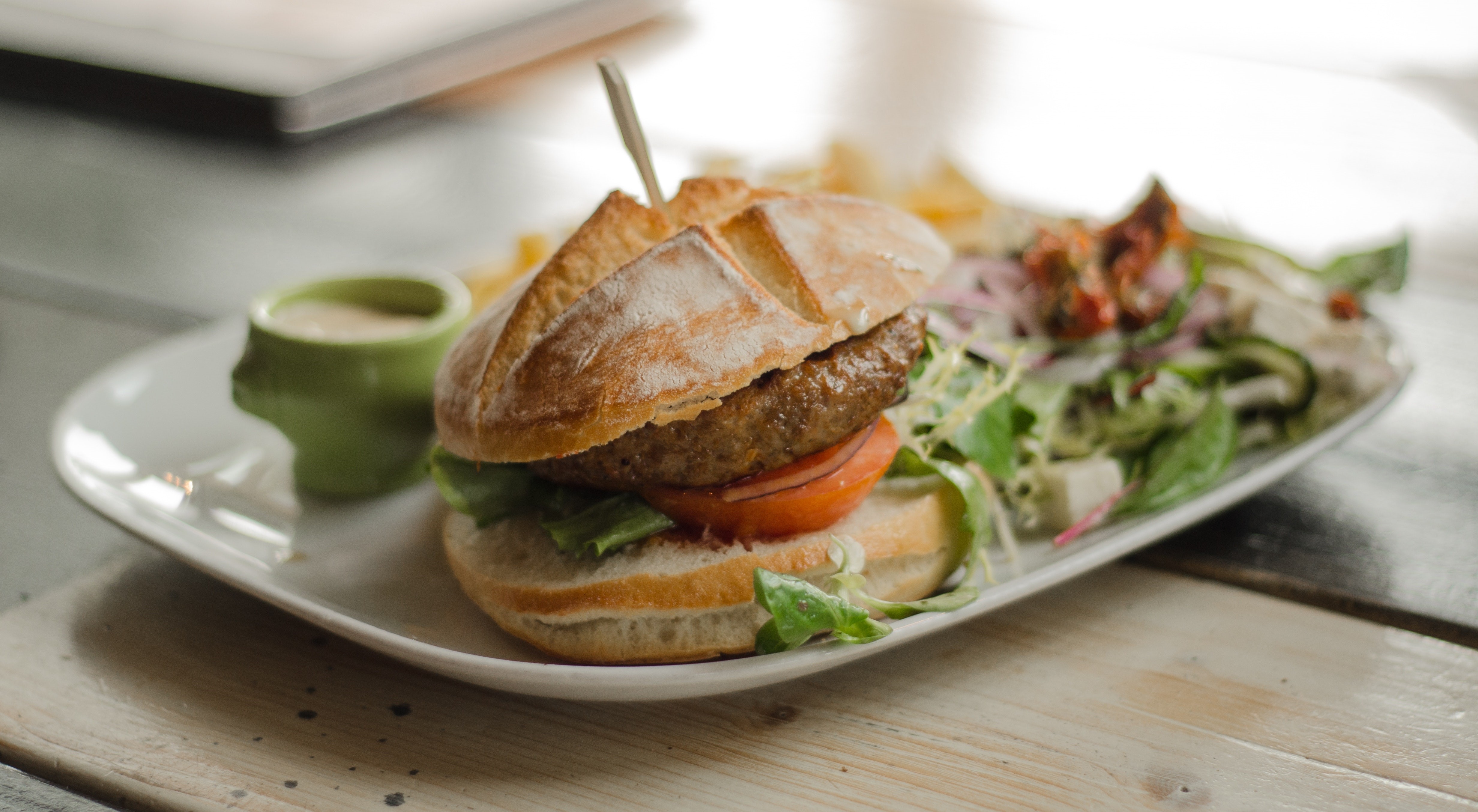 Burger with salad and fries on a wooden surface HD Wallpaper