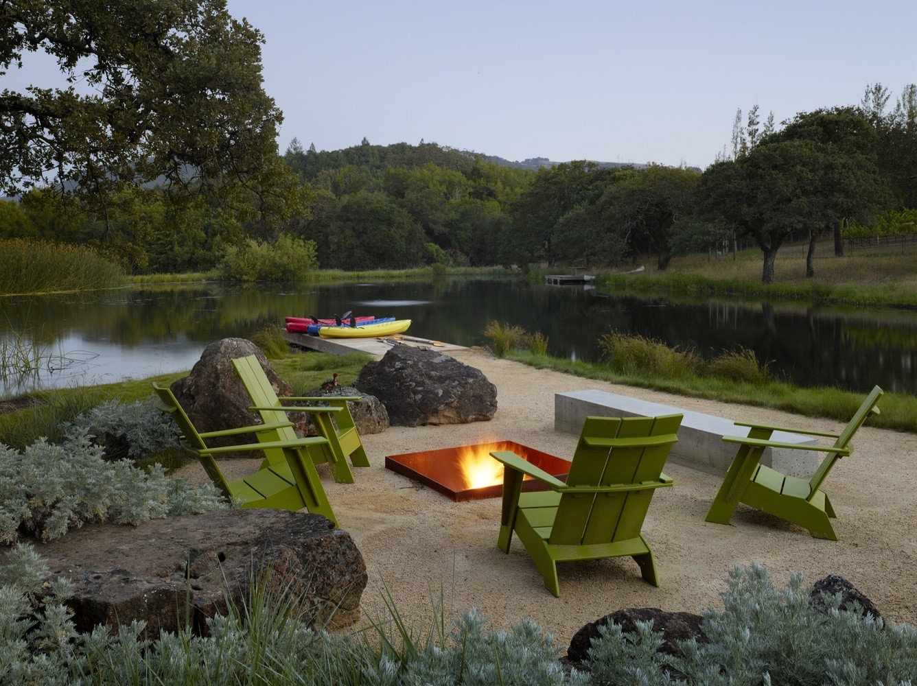 Outdoor seating area with fire pit by a lake HD Wallpaper