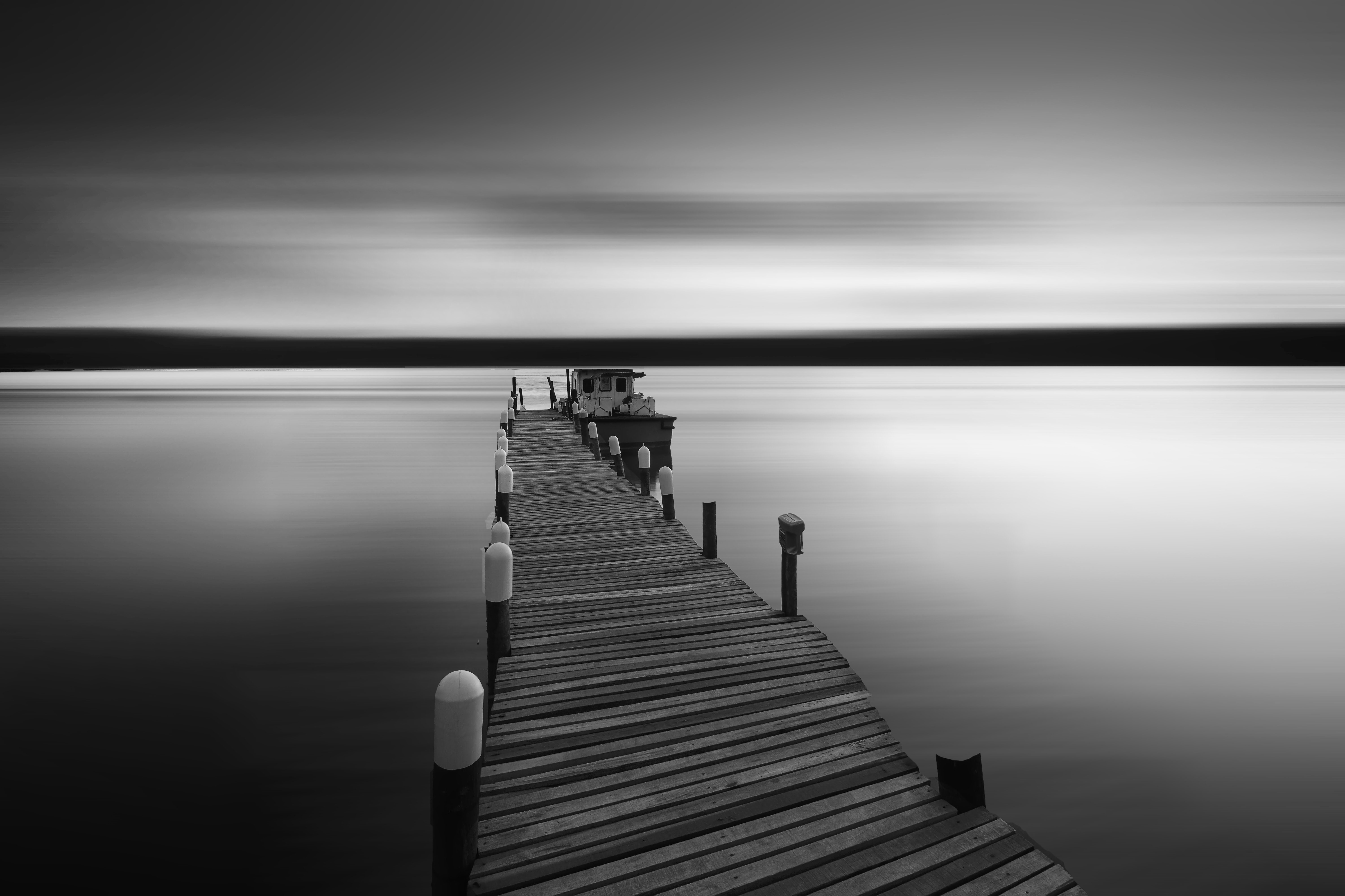 Monochrome pier with boat on water HD Wallpaper