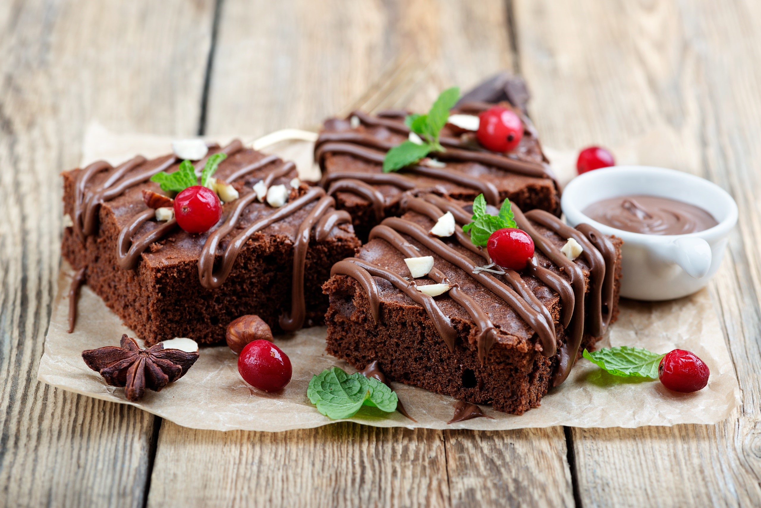 Chocolate brownies with berries and nuts on a wooden surface HD Wallpaper