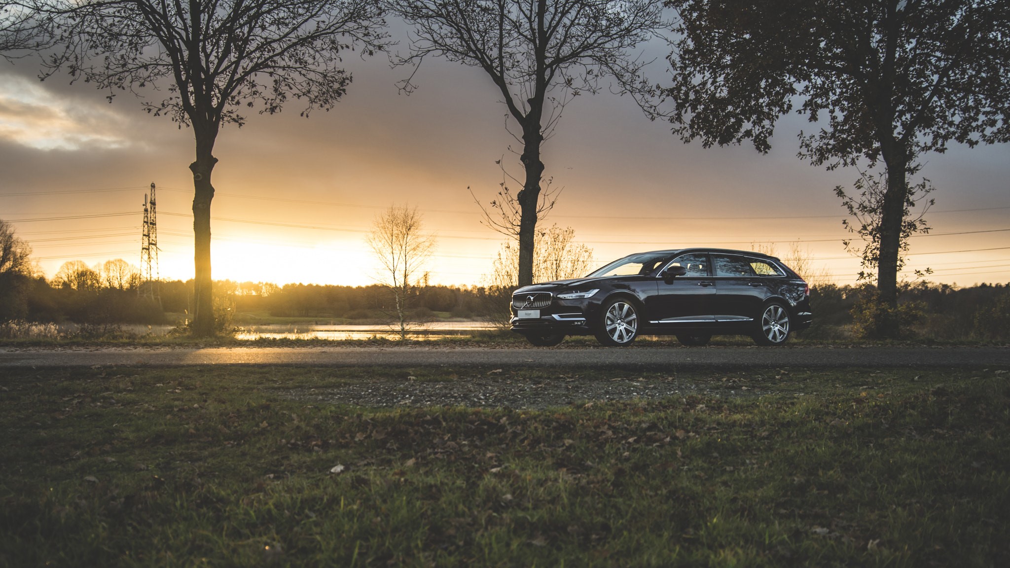 Dark Volvo V90 CC parked by a lake at sunset HD Wallpaper