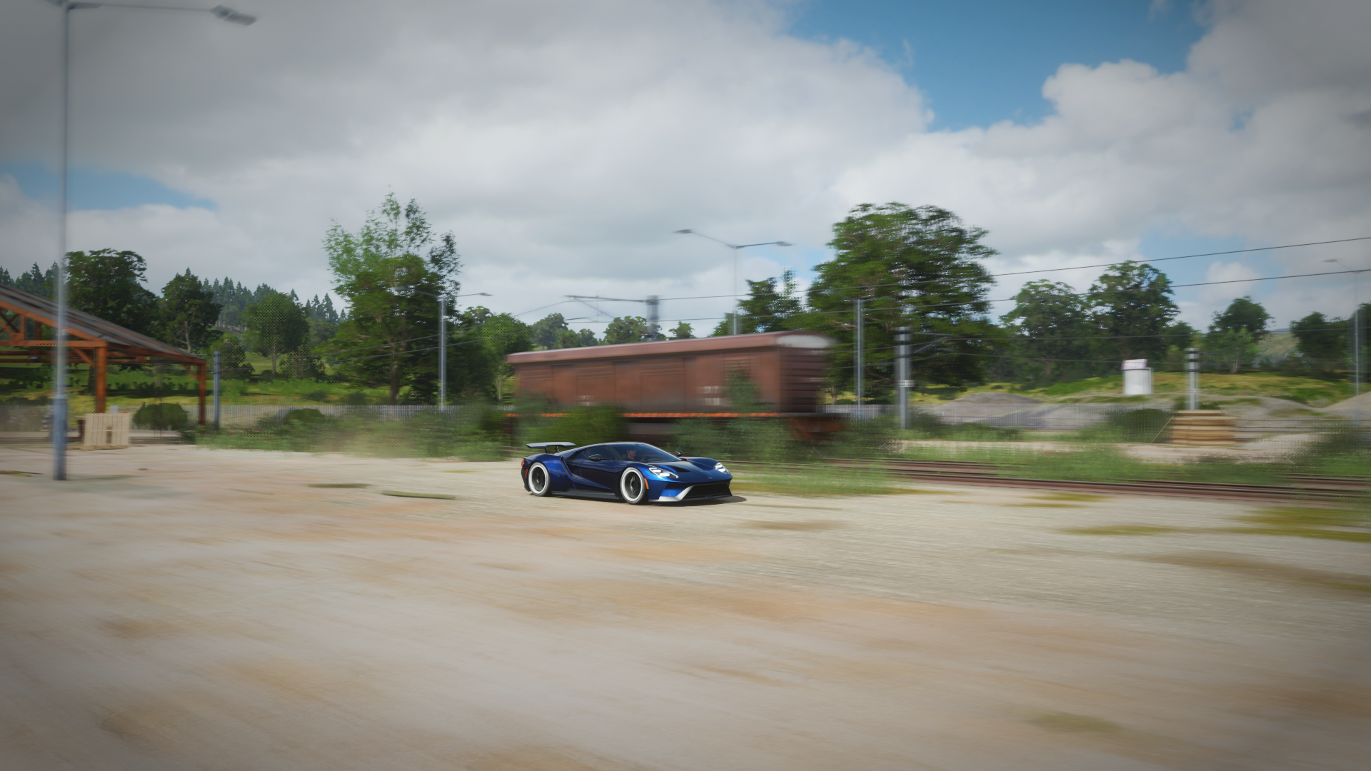 Blue Ford GT Mk II driving past a train in Forza Horizon 4 HD Wallpaper