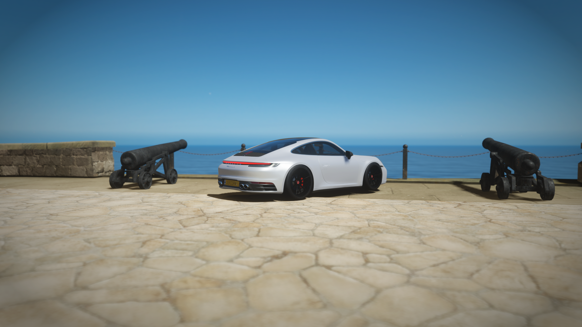 Porsche 911 992 on a sunny coast with cannons HD Wallpaper