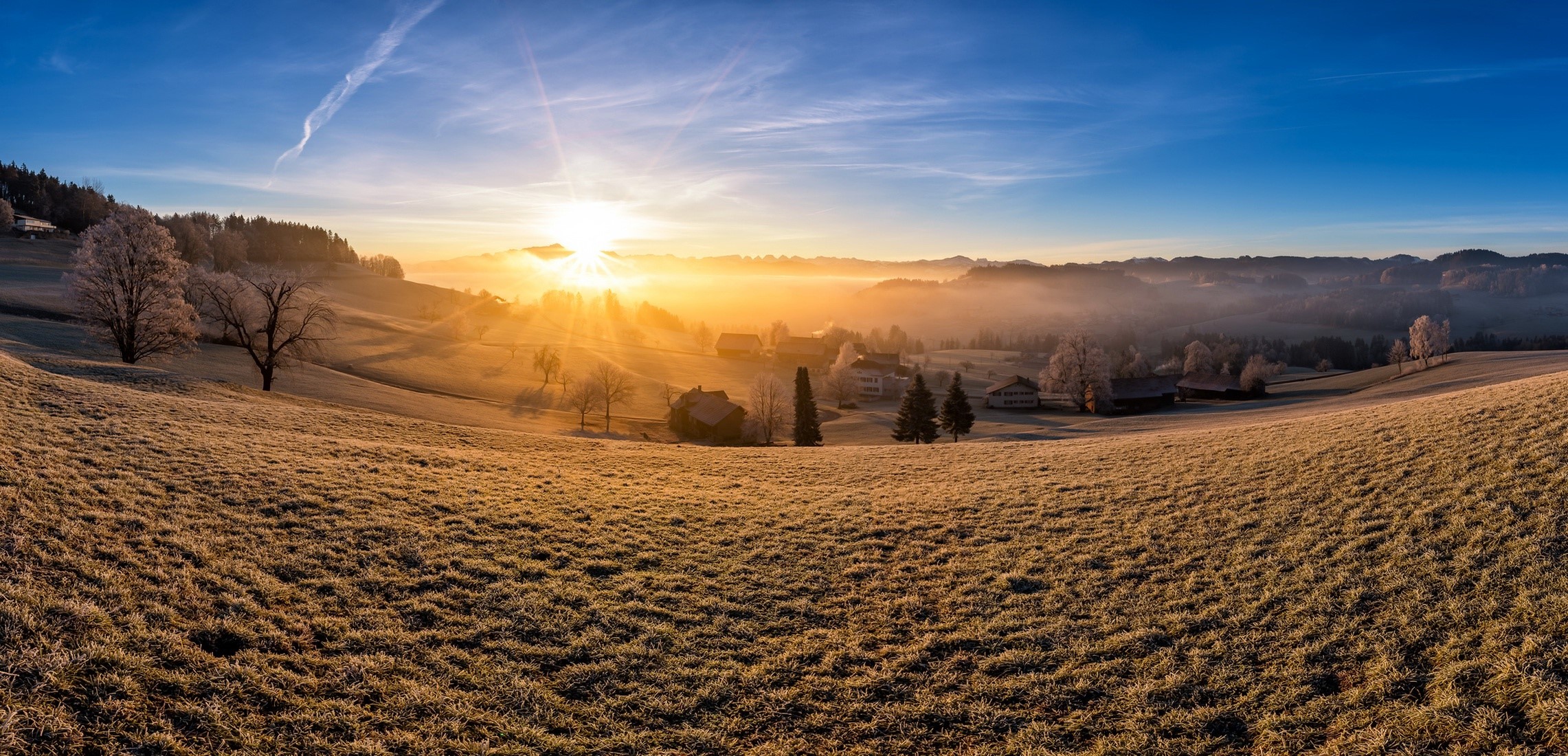Panoramic sunrise over a misty, frosted landscape with houses HD Wallpaper