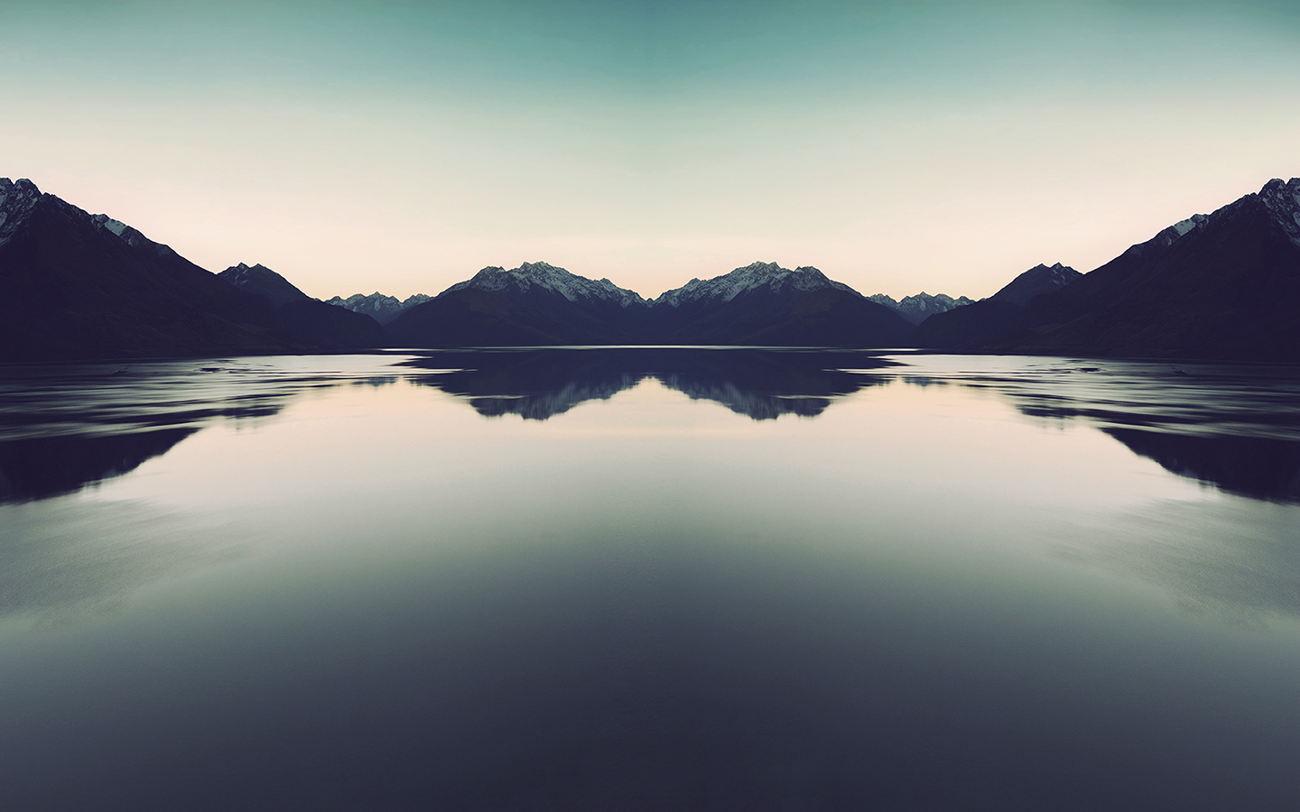 Symmetrical mountain range reflected in a calm lake HD Wallpaper